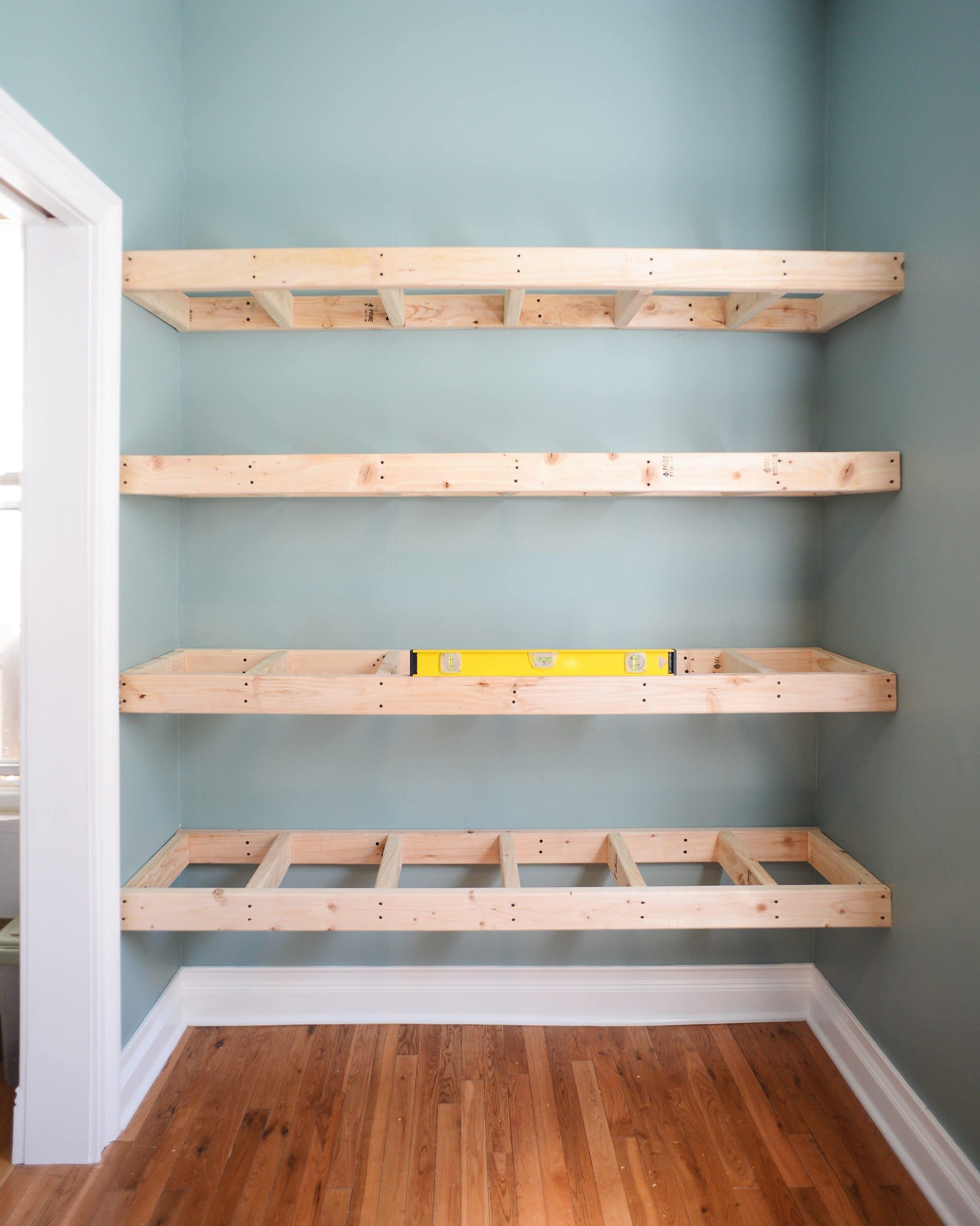 Always level when installing floating shelves. Level, level, level! | head to Yellow Brick Home for the step-by-step floating shelf tutorial!