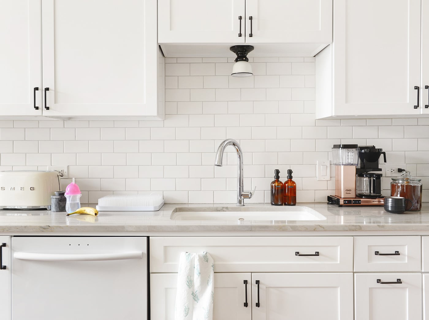 A white kitchen with amber soap pumps | via Yellow Brick Home