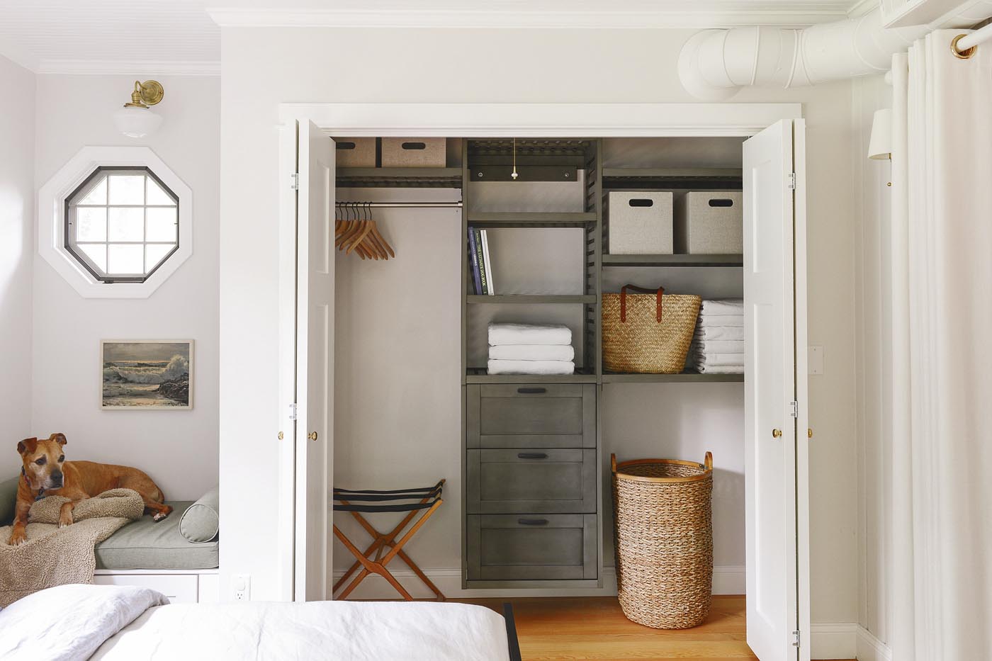 The primary bedroom closet in our Michigan Tree House uses a green-gray closet organizing system with built in drawers. 