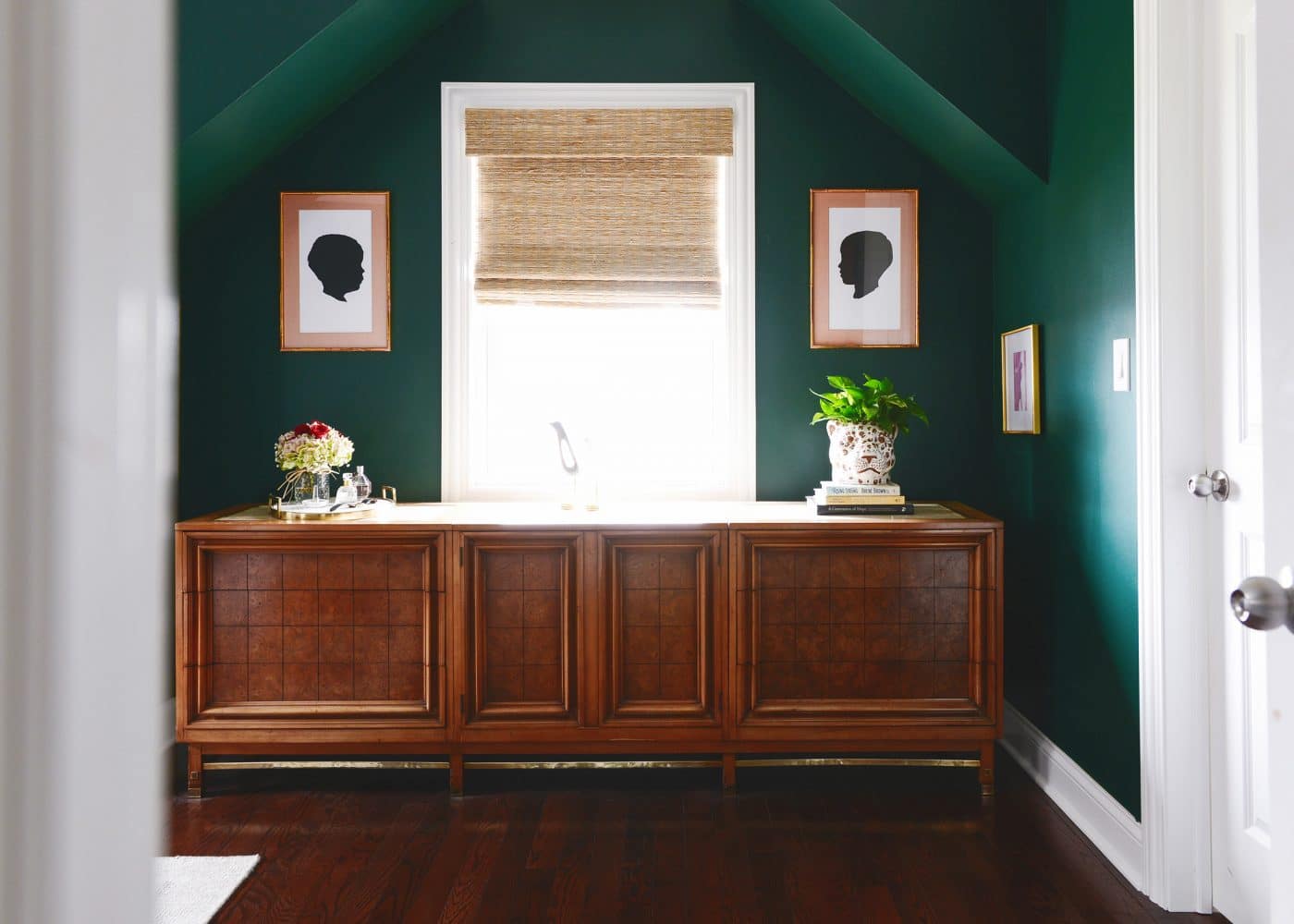 Dark green bedroom with silhouette art and large wooden credenza // via Yellow Brick Home