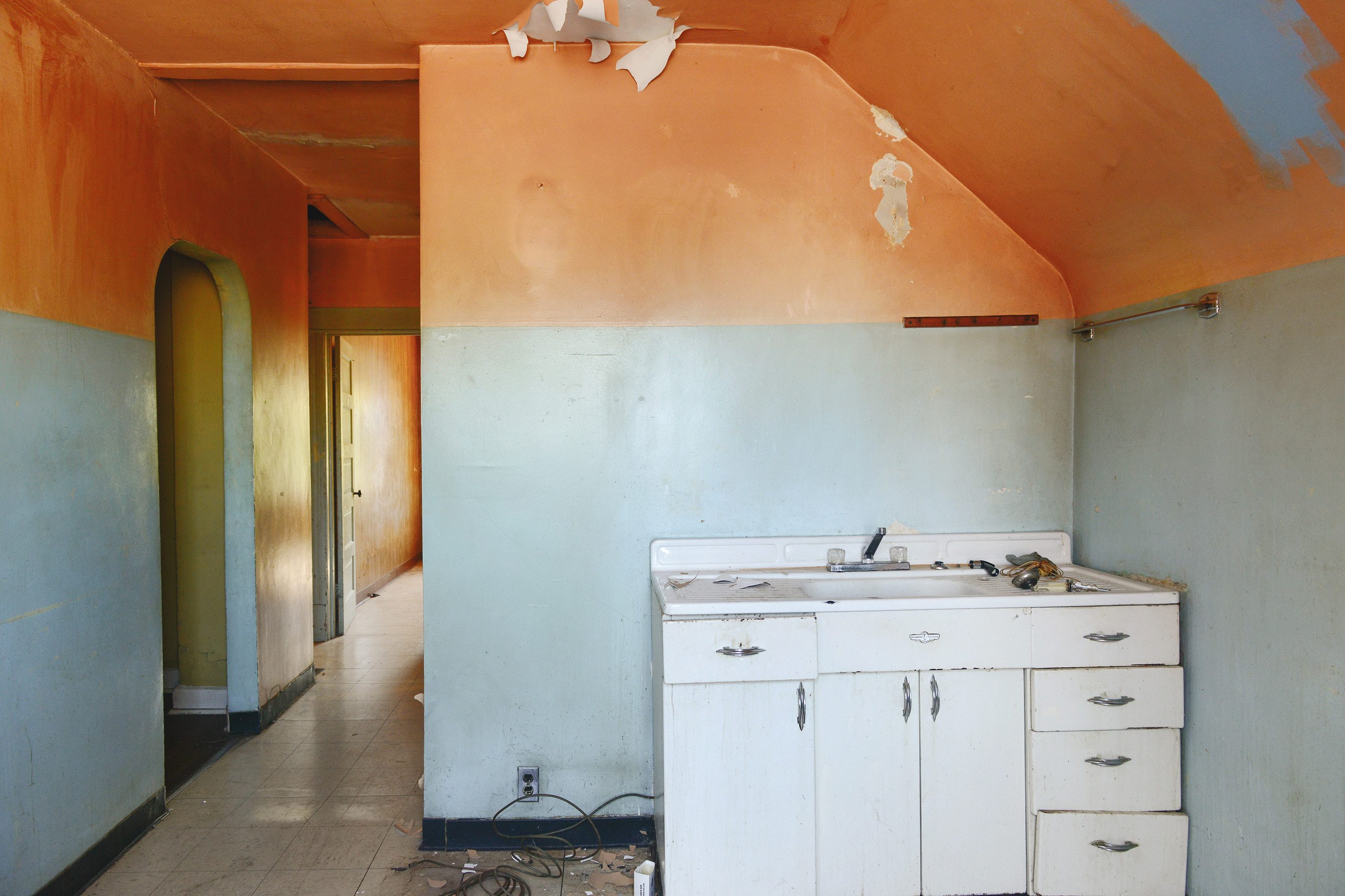 A 'before' photo of a dated kitchen with a sloped ceiling and peeling orange paint // via yellow brick home