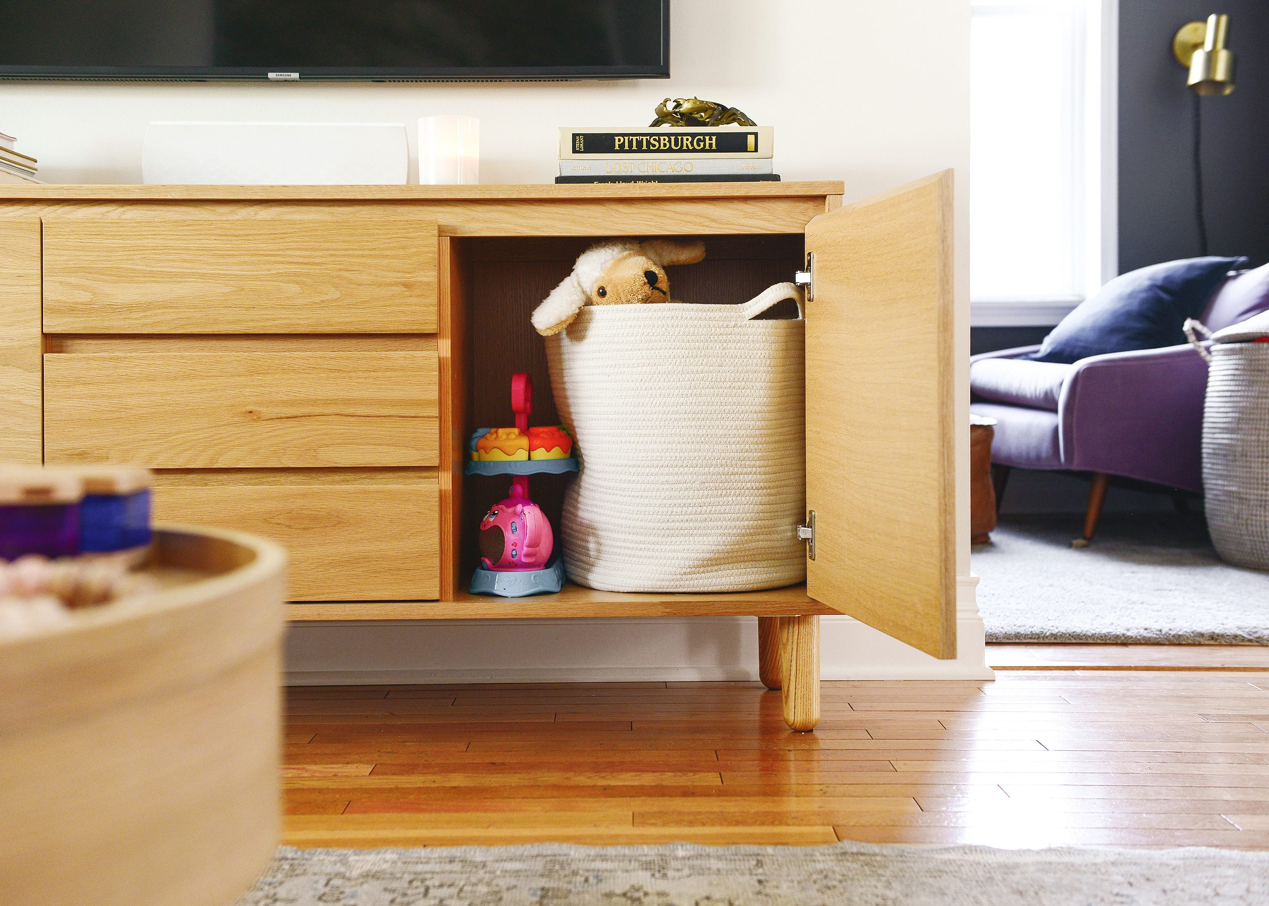 Hidden toy storage, tucked inside a media cabinet | via Yellow Brick Home