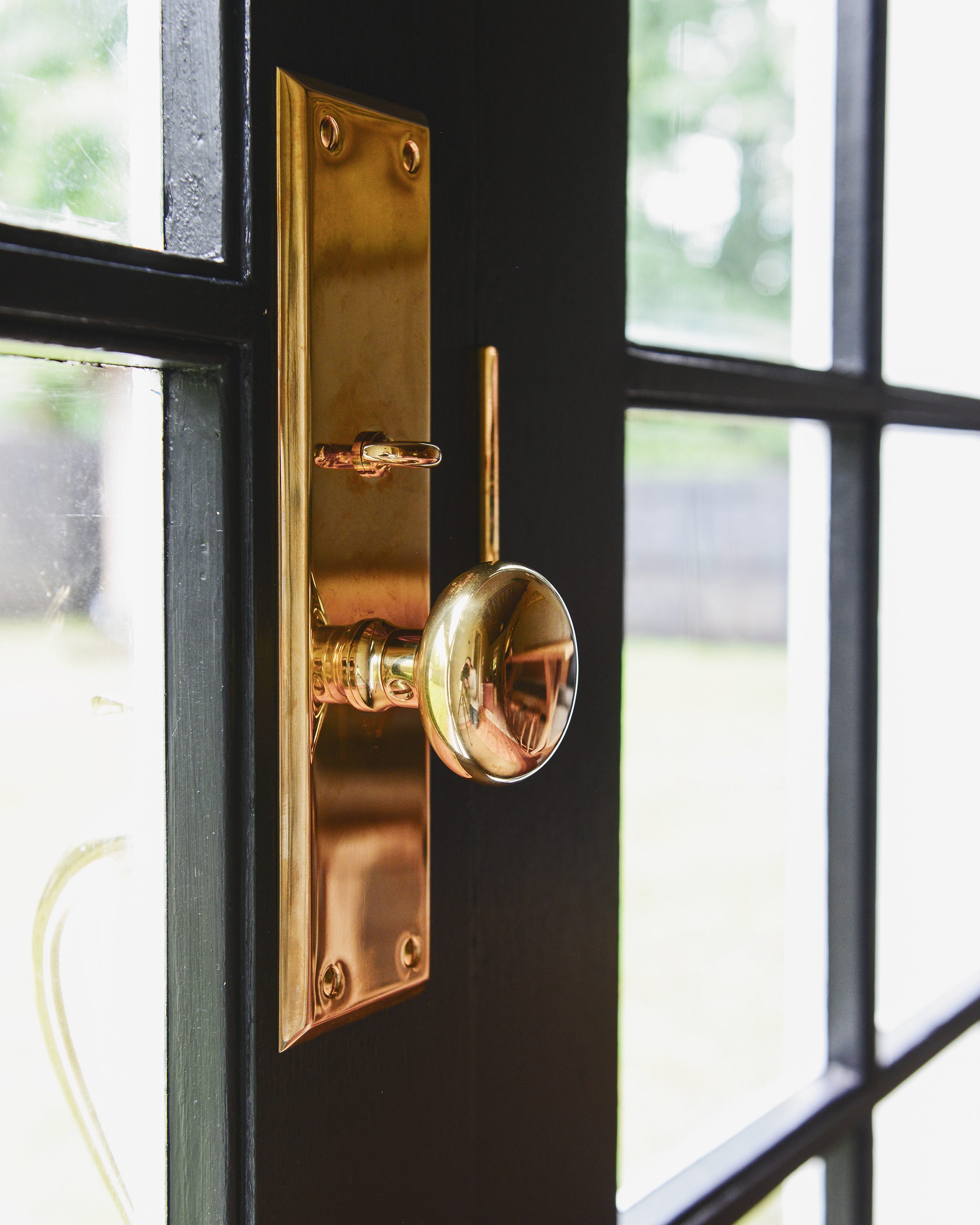 Painting our French doors Sherwin William's Black Magic with unlacquered brass hardware | via Yellow Brick Home