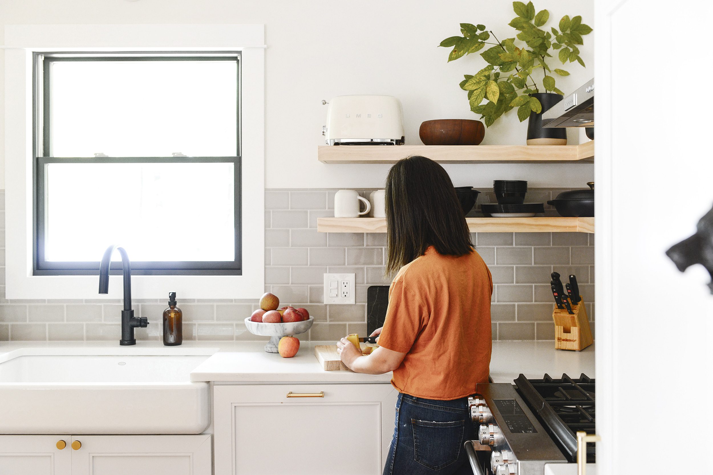 Homeowner slicing apples for an afternoon snack // Is open shelving in a kitchen the right choice for you? I'm sharing my tips for design + practicality, plus the one thing I'd do differently. | via Yellow Brick Home