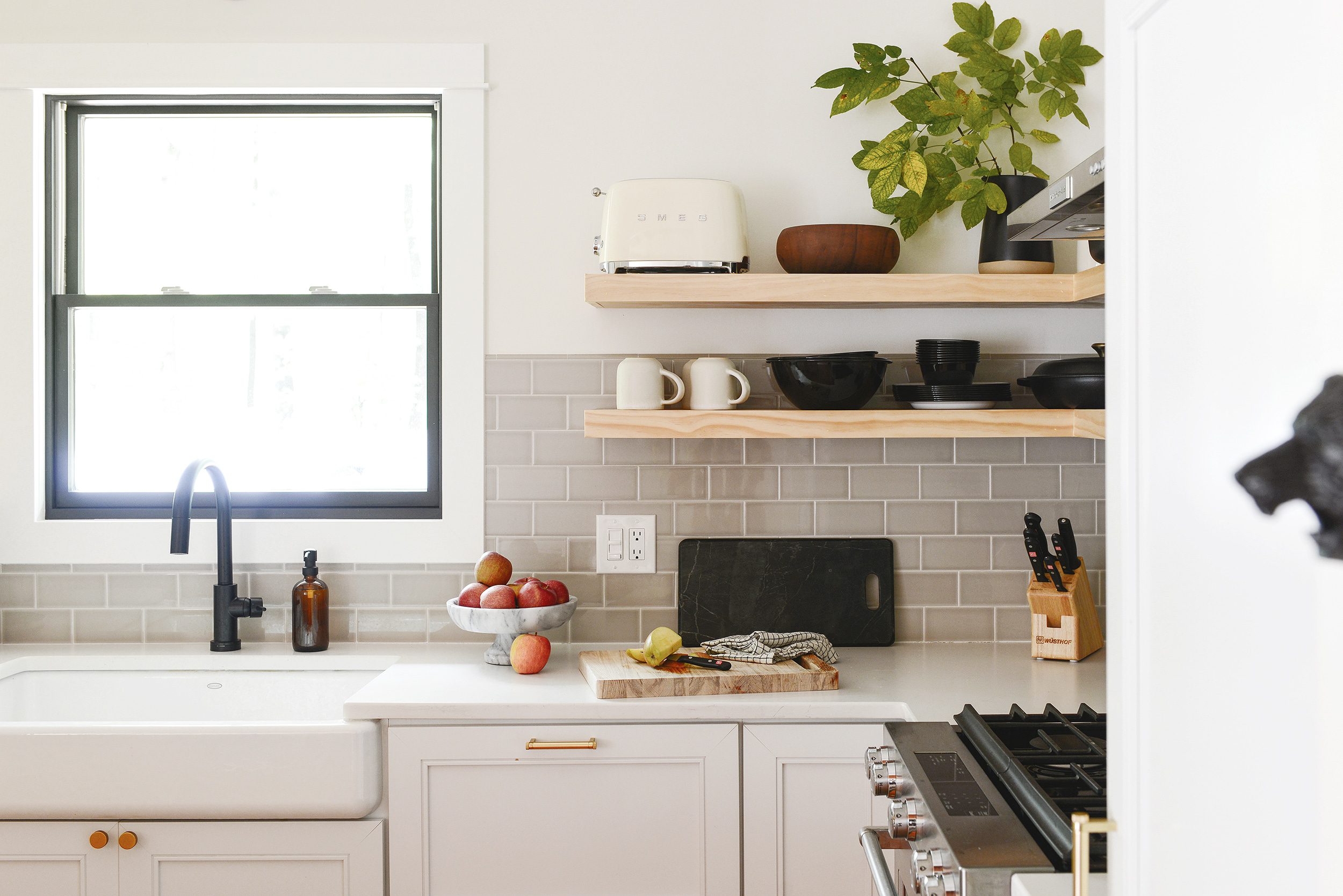 apples on the counter of an L-shaped kitchen  // Is open shelving in a kitchen the right choice for you? I'm sharing my tips for design + practicality, plus the one thing I'd do differently. | via Yellow Brick Home
