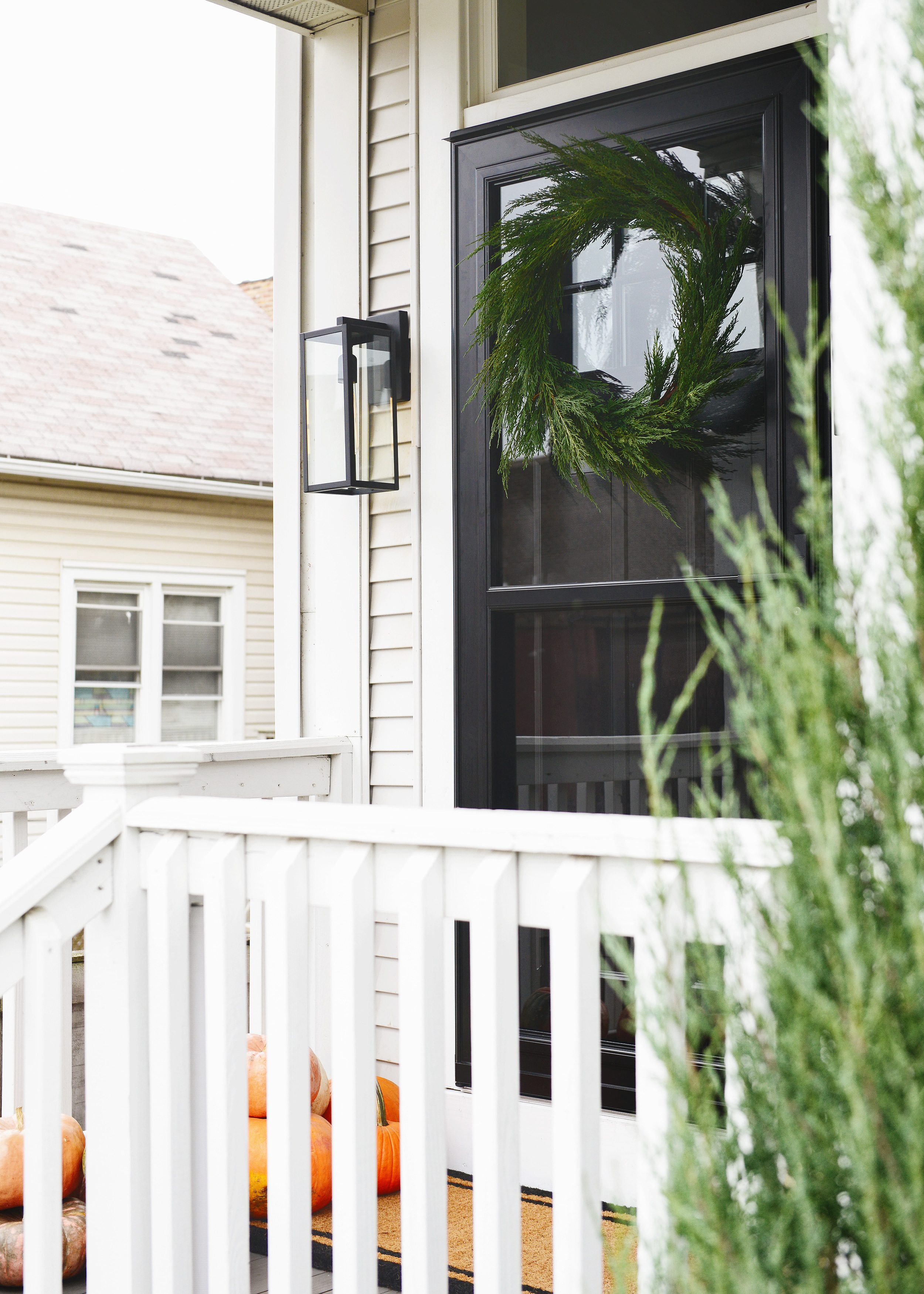 Our front porch today with a black door and black storm door: The 5 ingredients to a fall front porch refresh! via Yellow Brick Home