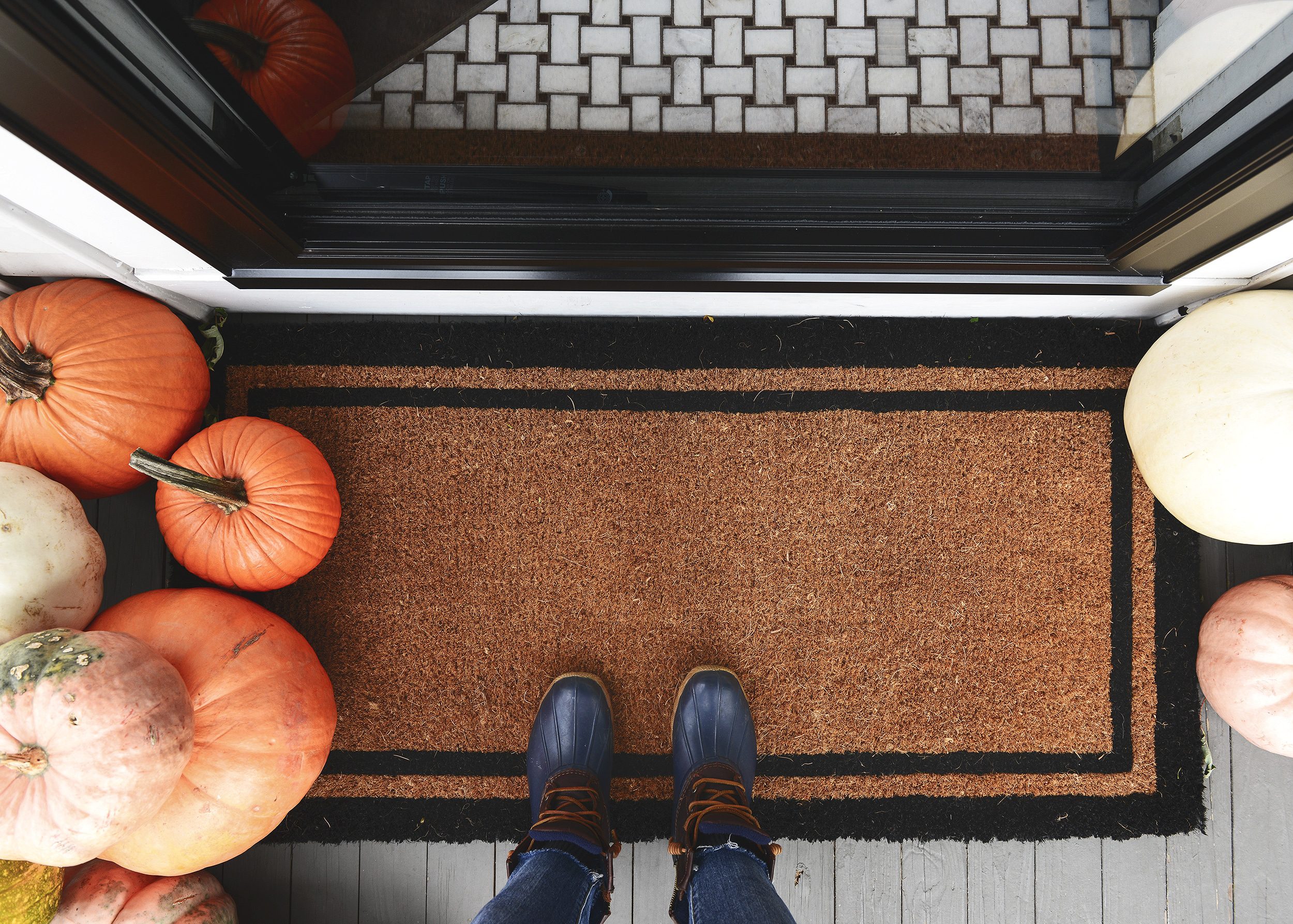 Extra wide coir doormat with black trim + a pile of pumpkins: The 5 ingredients to a fall front porch refresh! via Yellow Brick Home