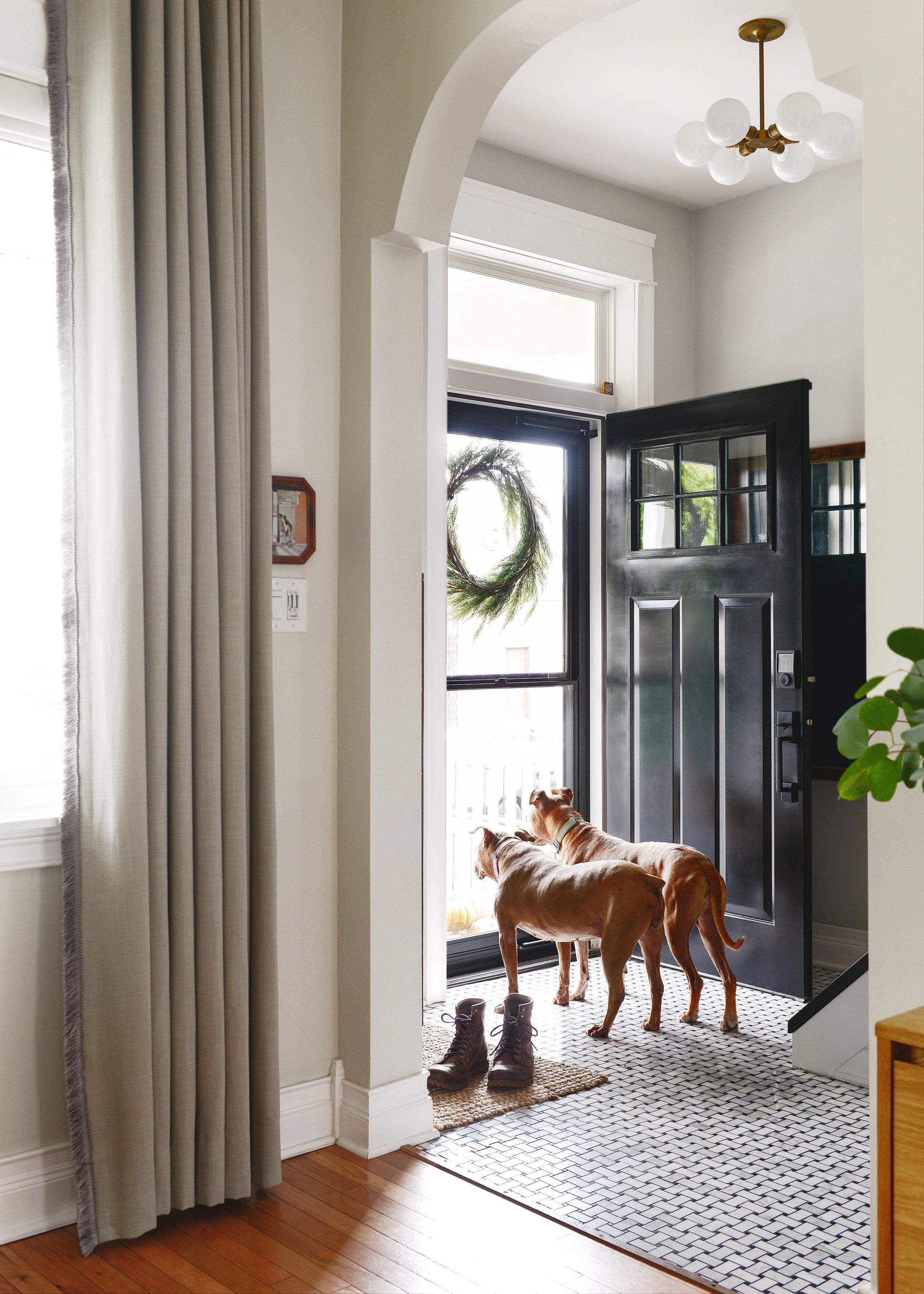 Jack and CC looking out the storm door, standing inside our entryway: The 5 ingredients to a fall front porch refresh! via Yellow Brick Home