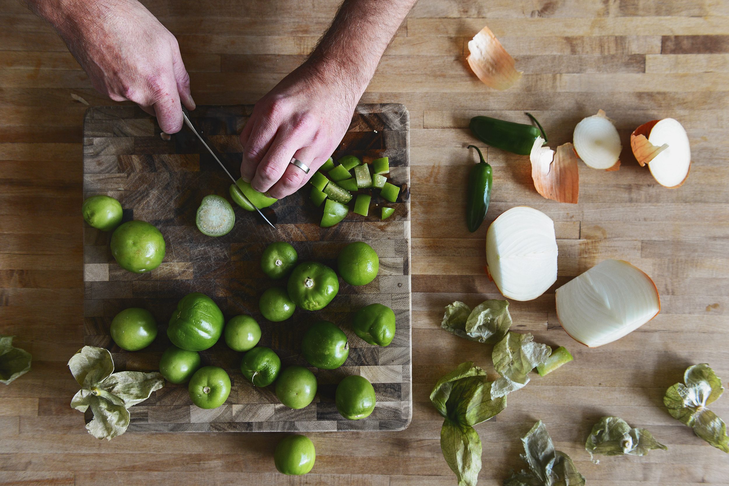 Chopping tomatillos and onions | Our White Chicken Chili! Full of tomatillos and chunky chicken, we top it with sliced avocado and heaps of cilantro. via Yellow Brick Home