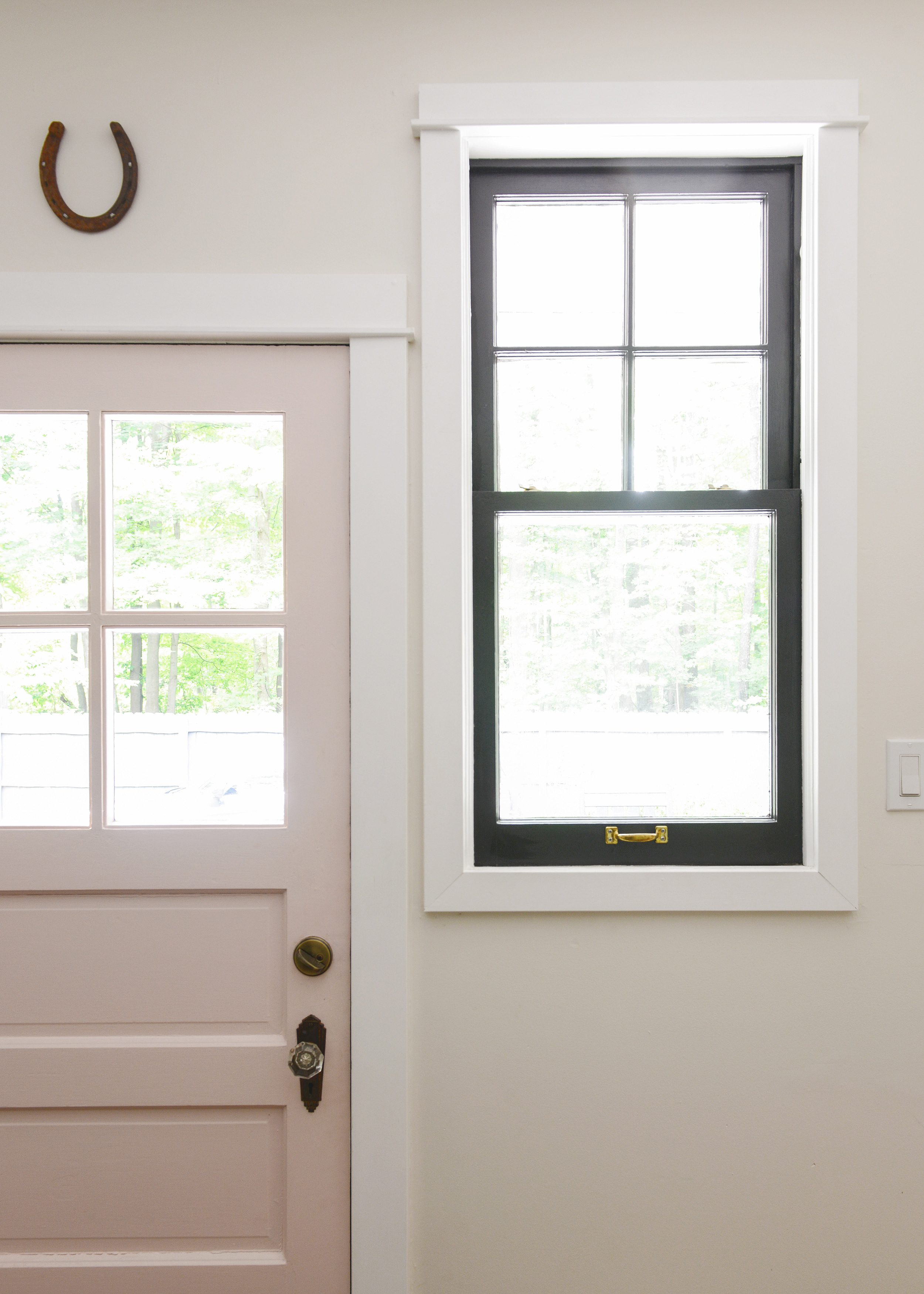 An up close shot of a mudroom with a pink door and a black window // Indow window inserts for comfortable, energy efficient homes via Yellow Brick Home, in partnership with Indow