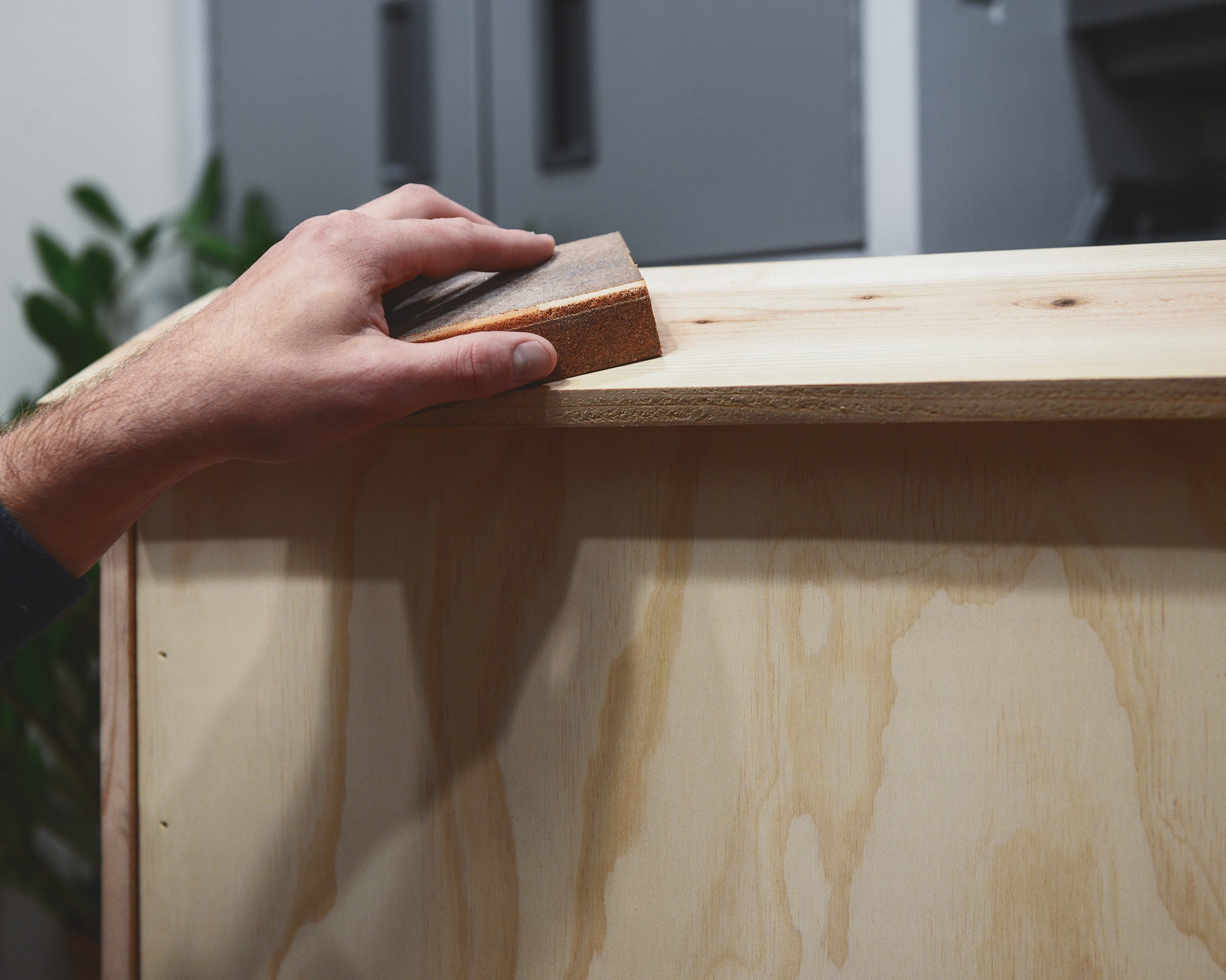Sanding the roof panel of a completed DIY bat box // How-to build a bat box, DIY bat box via Yellow Brick Home