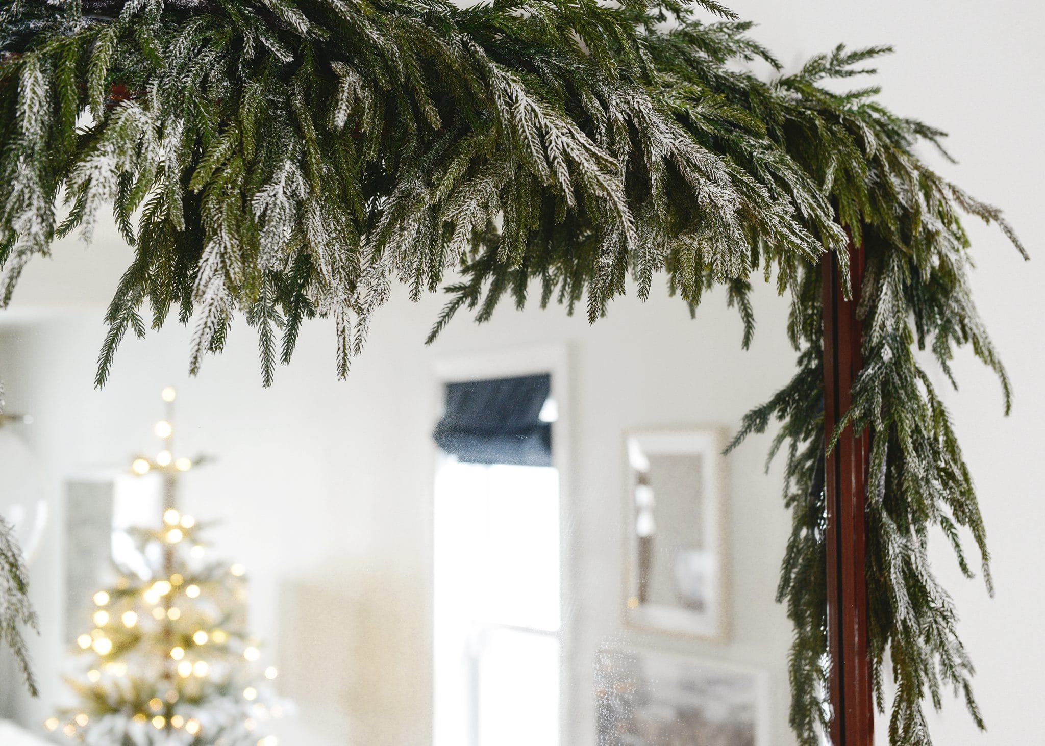 Detail shot of Sno Blast on our faux garland, hung above our mirror | Which flocking spray is best? | How to flock your own holiday garland, tree and decor, via Yellow Brick Home
