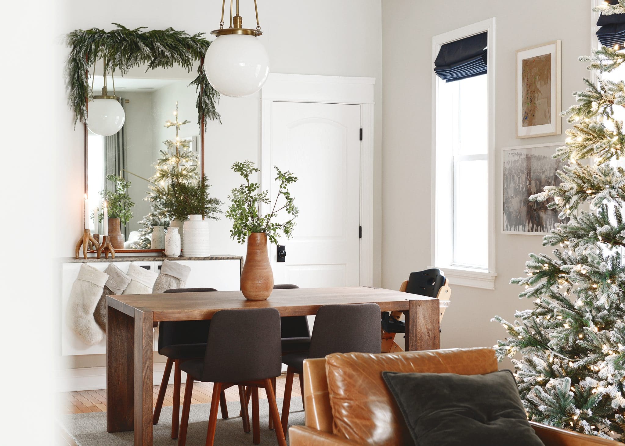 A living and dining room decked out in holiday decor, faux garland and faux tree | Which flocking spray is best? | How to flock your own holiday garland, tree and decor, via Yellow Brick Home