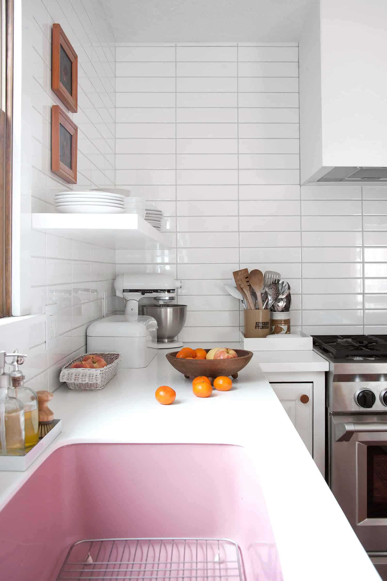All white kitchen with a link pink and a bowl of oranges on the counter | Inspiration for Stacked Tile, stacked bond tile pattern, via Yellow Brick Home
