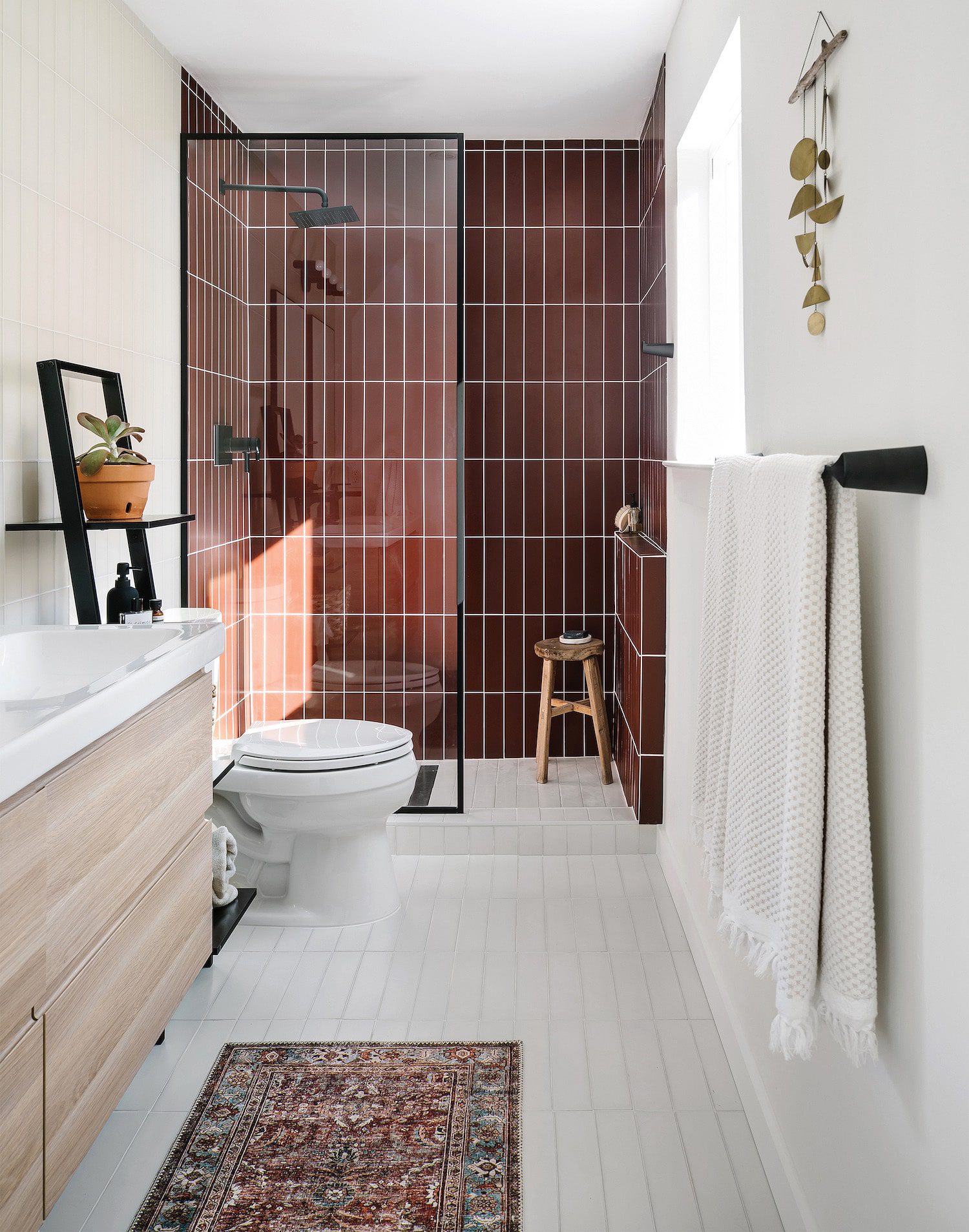 Bathroom with maroon tile in the shower and white tiled floors | Inspiration for Stacked Tile, stacked bond tile pattern, via Yellow Brick Home