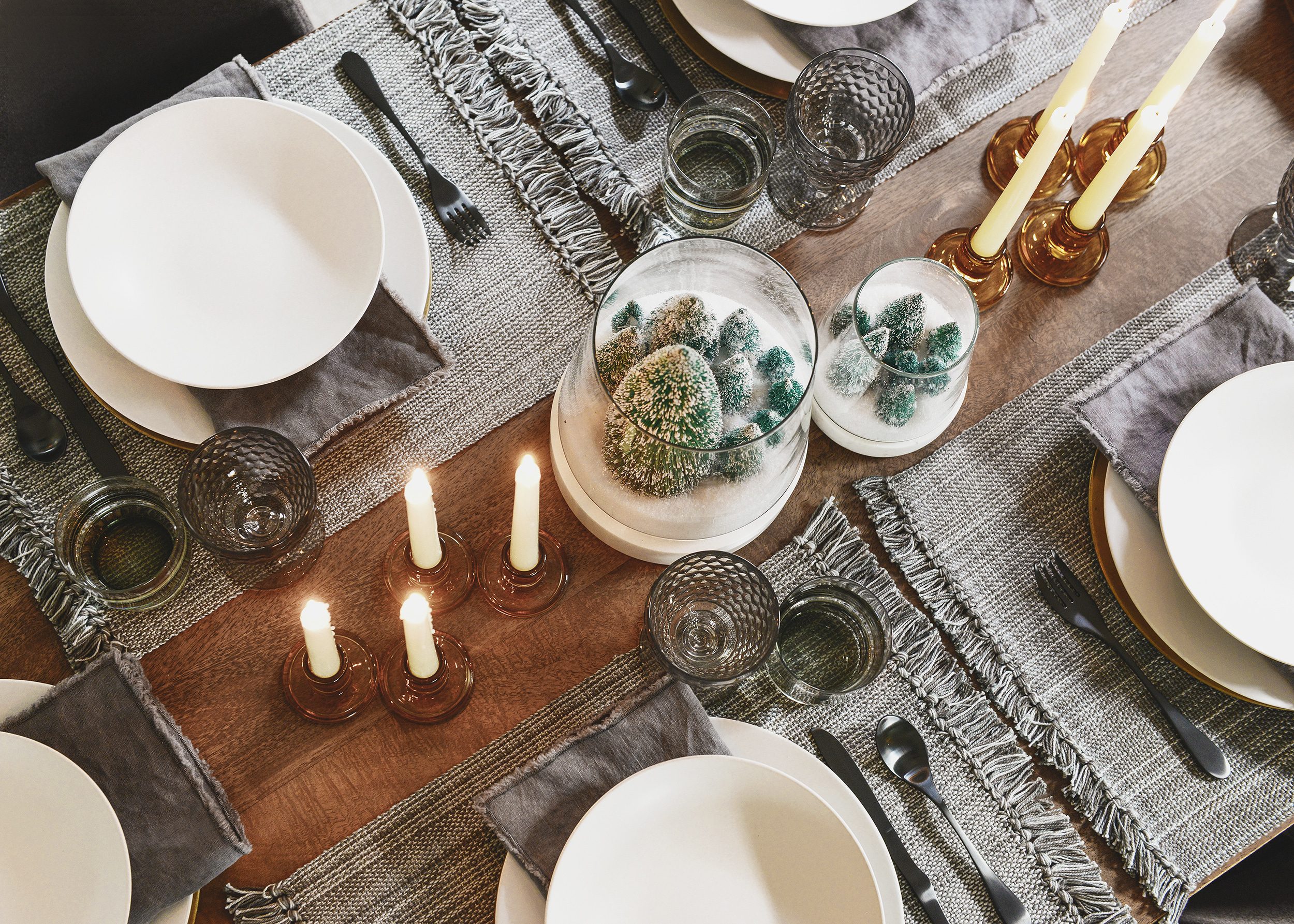 An overhead shot of a holiday table setting in shades of grey, amber and white | This holiday season, consider simplifying your table setting with these 5 fresh styling tips! | via Yellow Brick Home