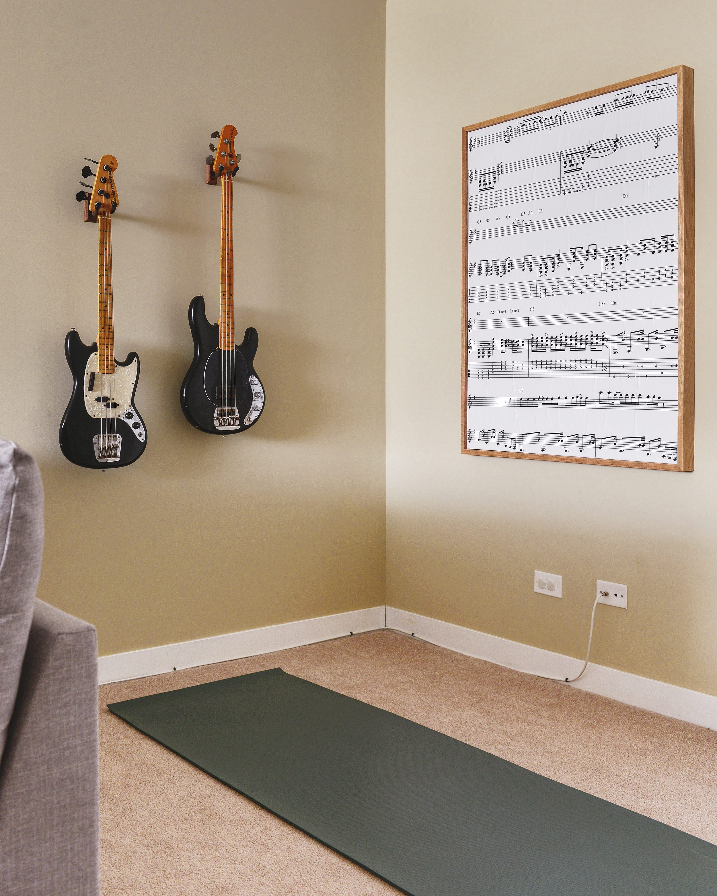 A calm corner of a family room with guitars on the wall, DIY art and a yoga mat | via Yellow Brick Home