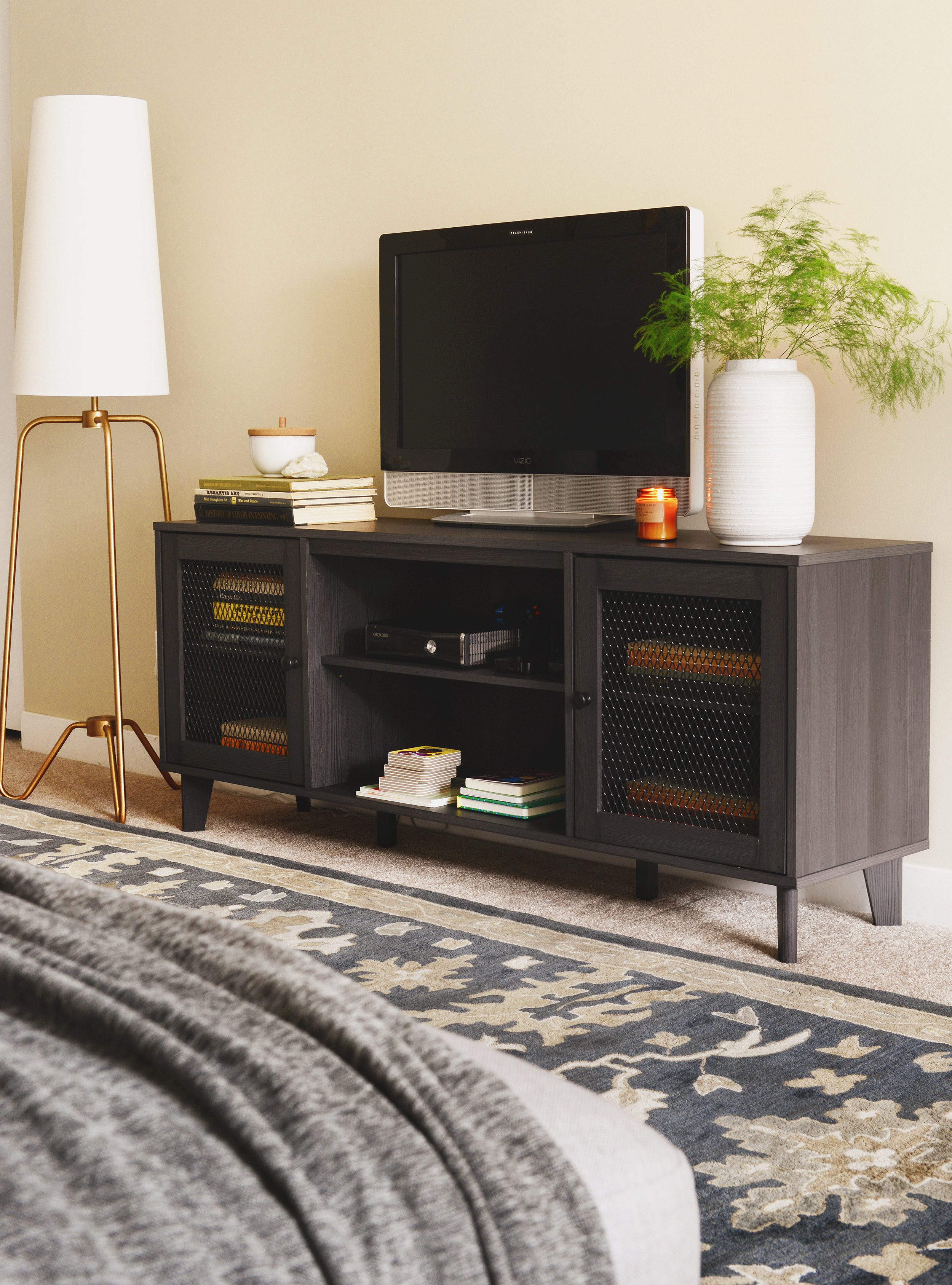 Dark gray media console with brass floor lamp and navy rug | via Yellow Brick Home
