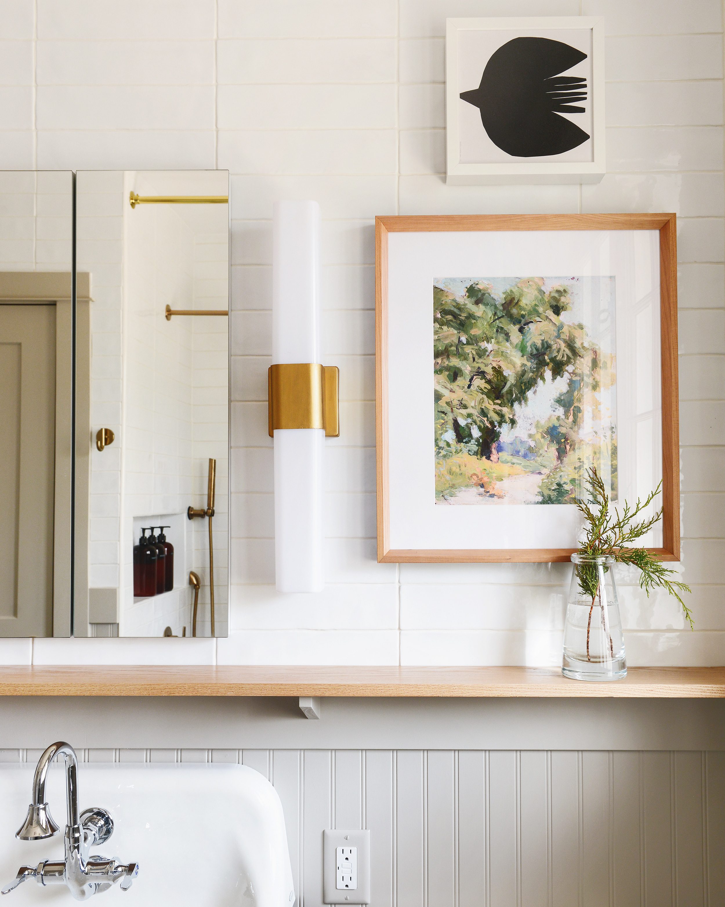 A green, griege and brass bathroom with nature artwork and brass sconces | via Yellow Brick Home 