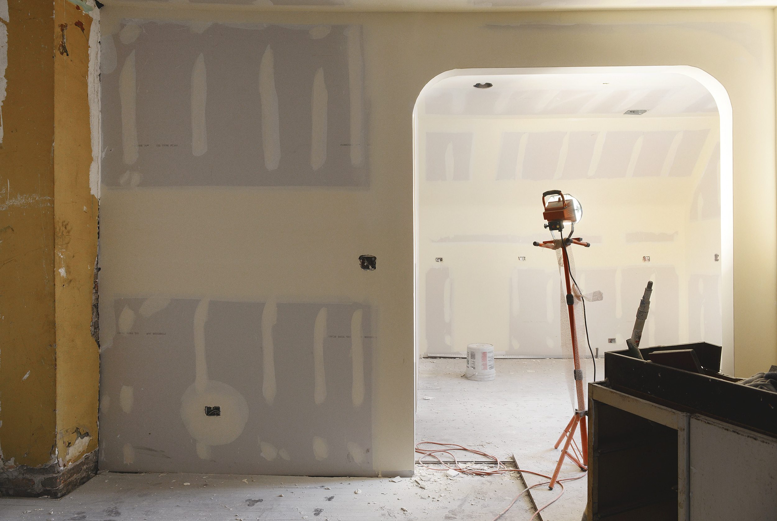 A freshly drywalled arch between a living room and kitchen under construction // via Yellow Brick Home 