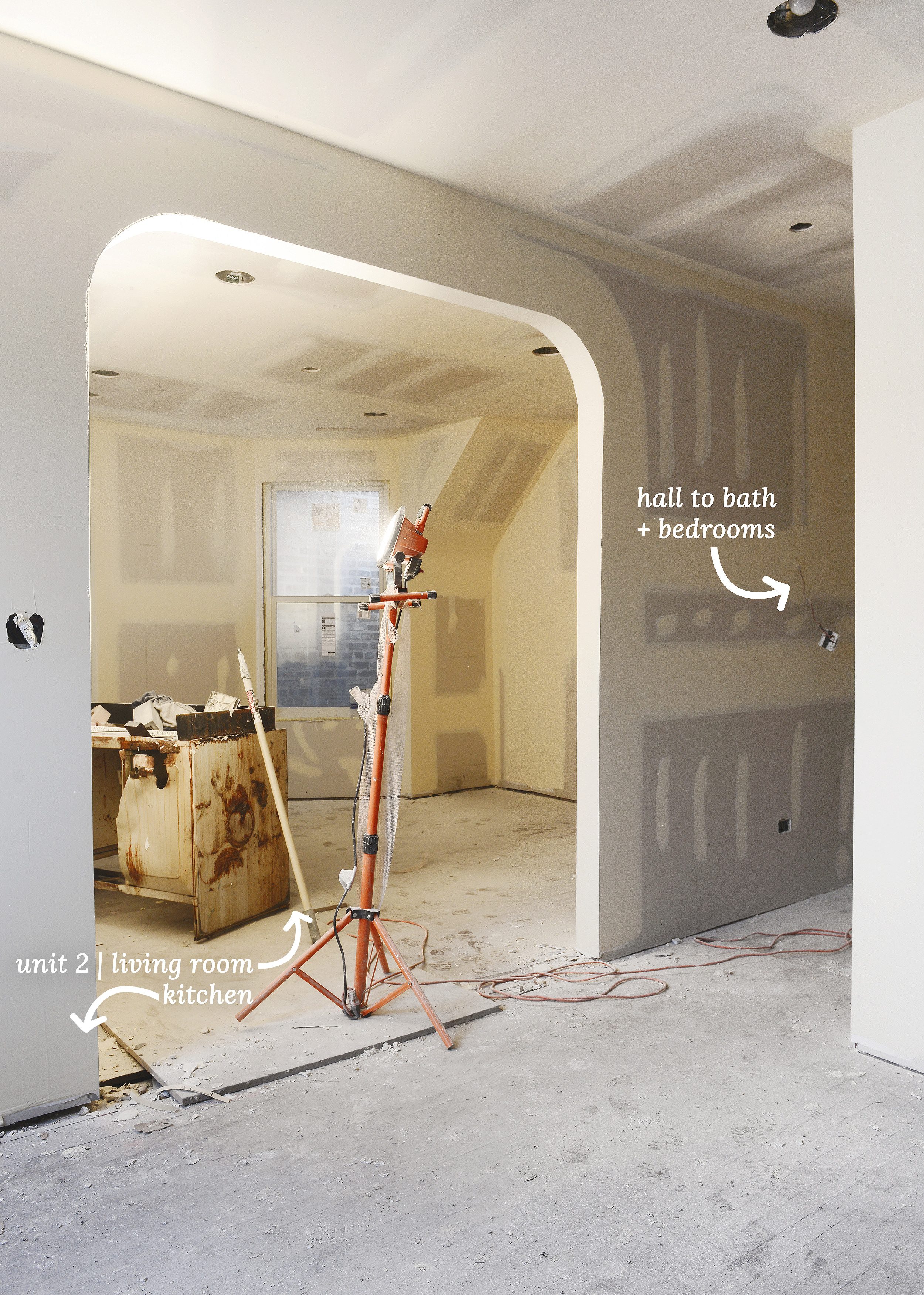 A freshly drywalled arch between a living room and kitchen under construction // via Yellow Brick Home