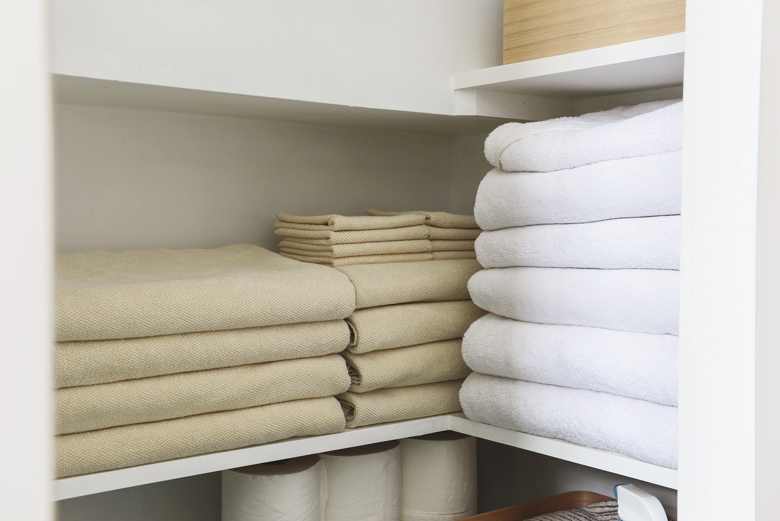 A compact linen closet is stocked with towels and bathroom supplies // via Yellow Brick Home