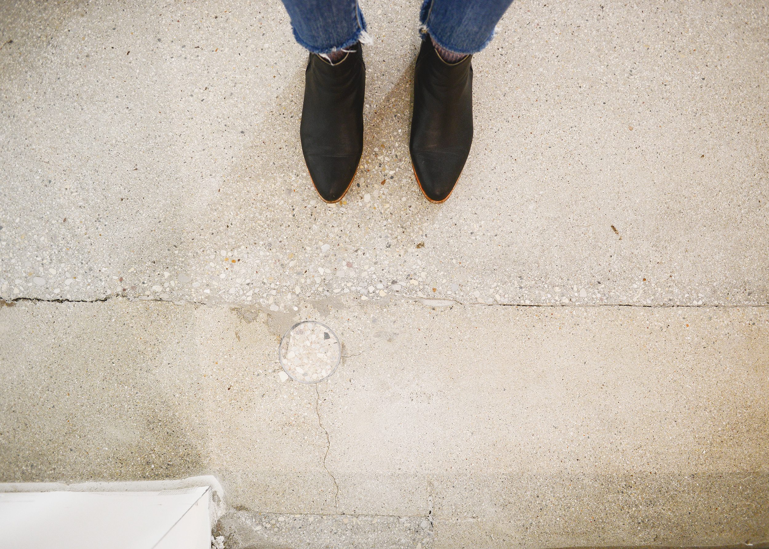 Black boots on unpolished concrete floors with imperfections | via Yellow Brick Home