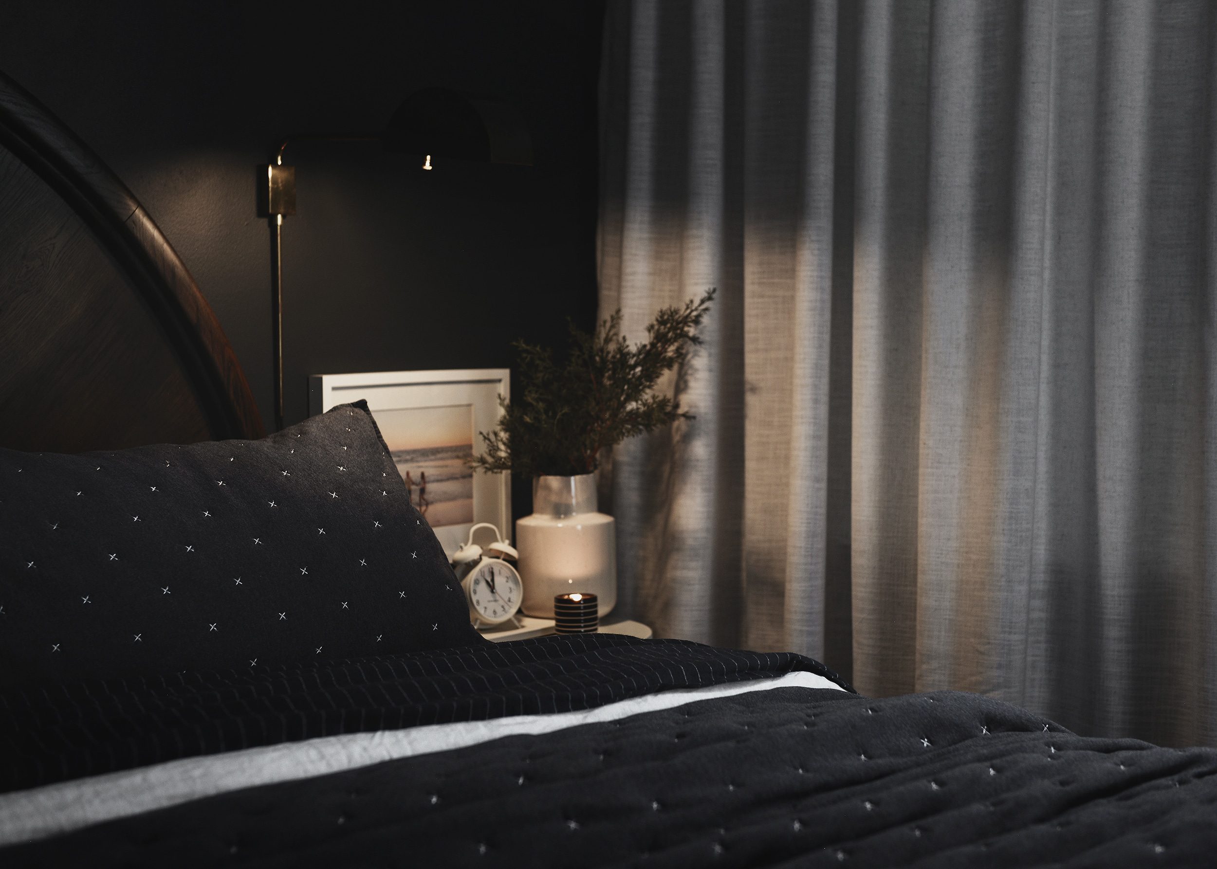 A moody bedroom design with Benjamin Moore Raccoon Fur walls, navy bedding and soft lighting | via Yellow Brick Home