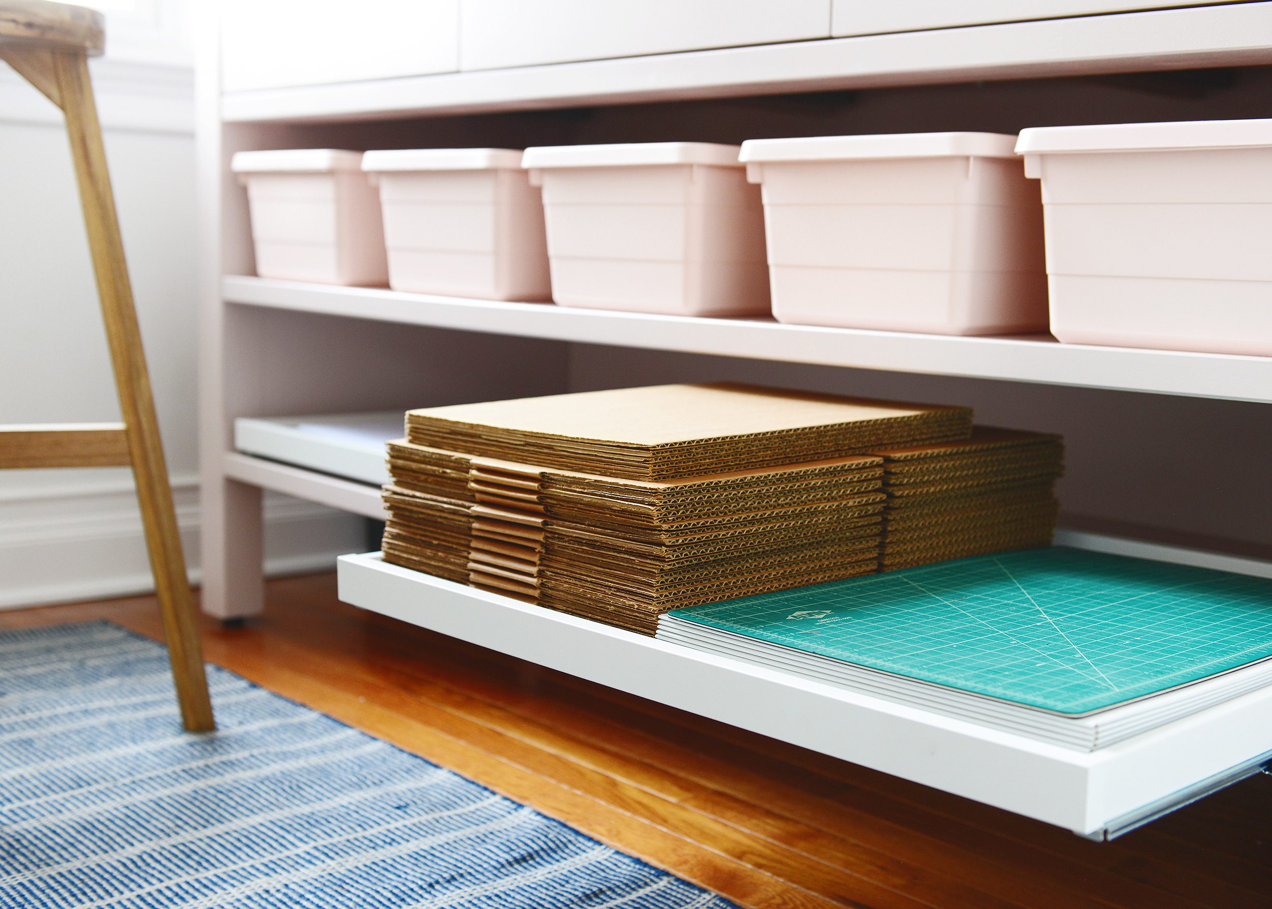 A pull out shelf using IKEA trays to store shipping supplies. Nothing can get lost in the back anymore! via Yellow Brick Home