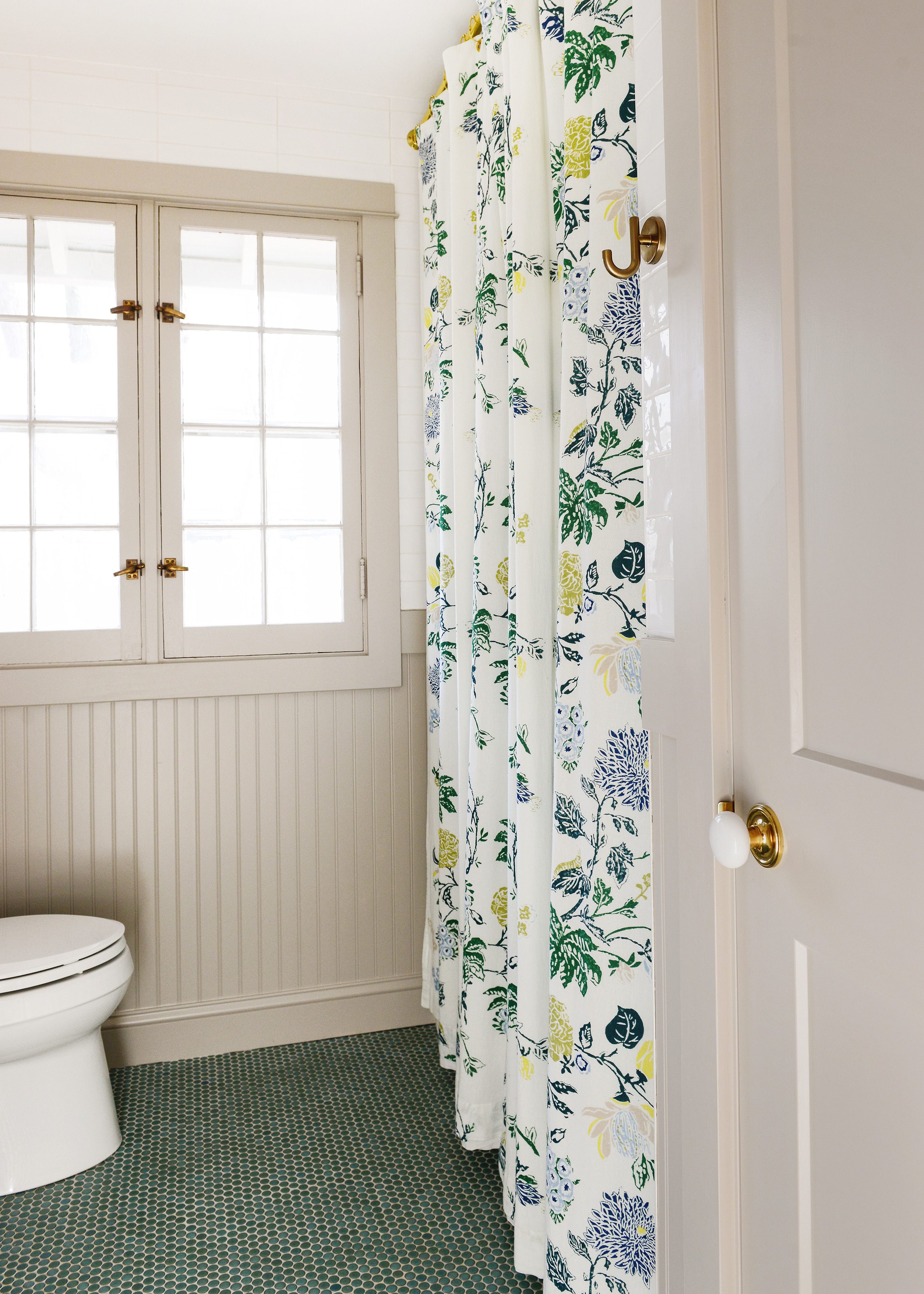 Our extra long shower curtain in our lake house bathroom, featuring green penny tile and greige beadboard | via Yellow Brick Home
