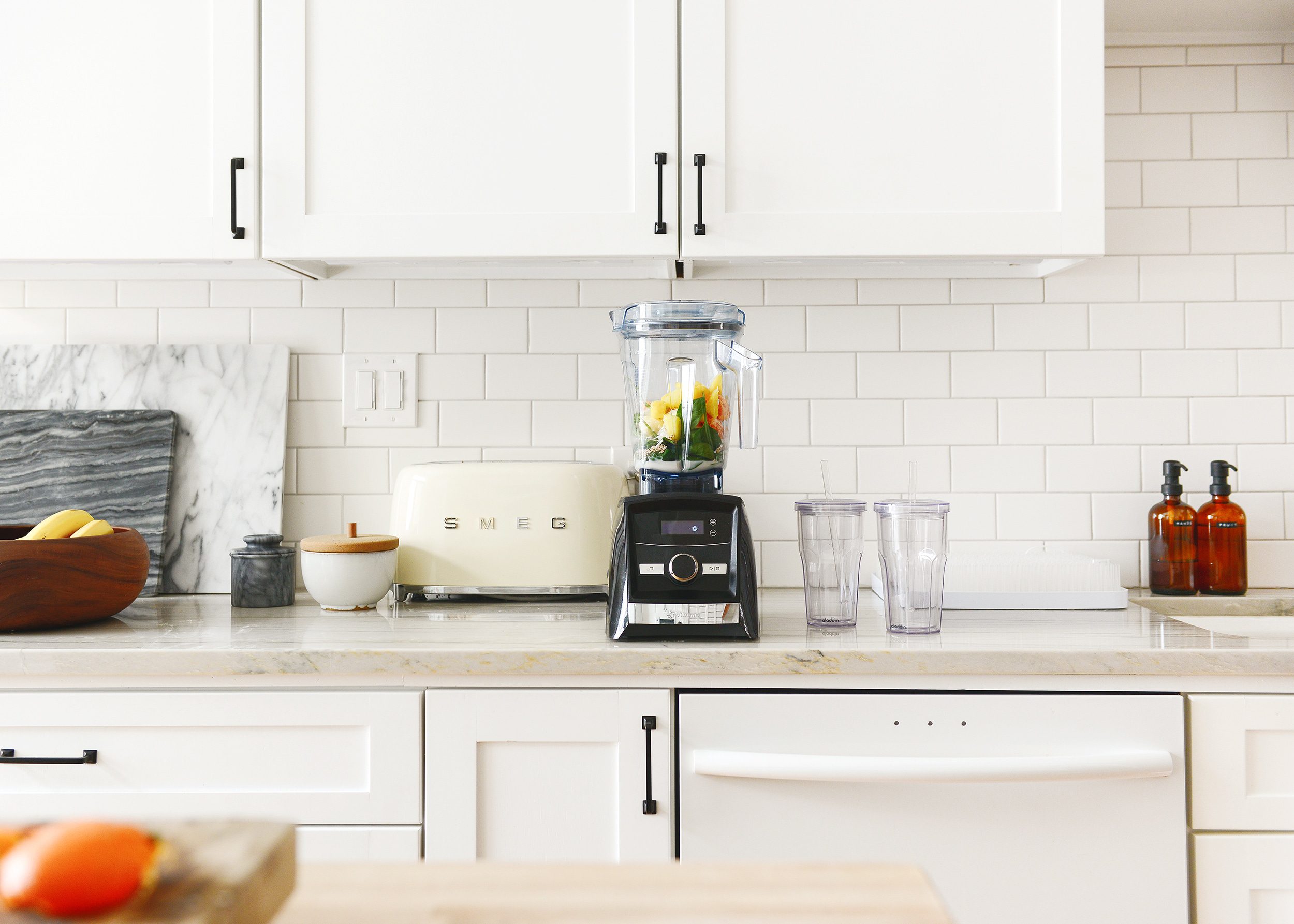 A blender in a white kitchen with marble-like countertops. Best smoothie recipe for a cold! via Yellow Brick Home