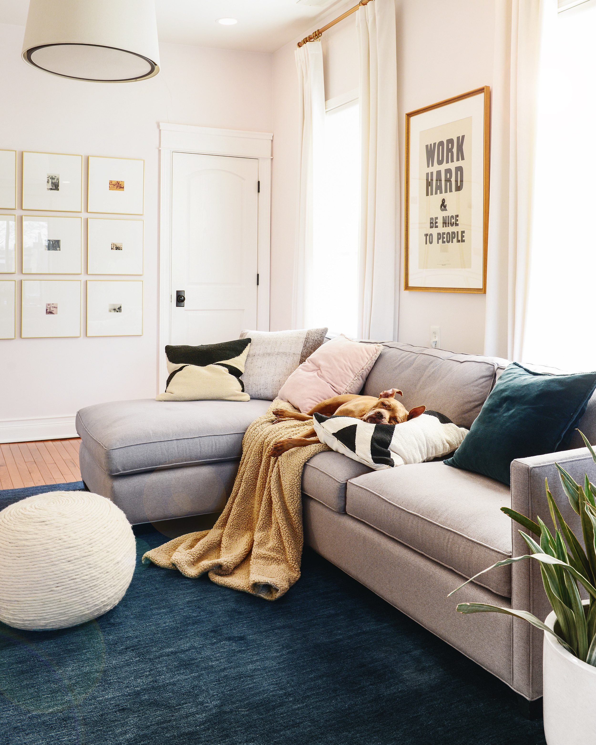 Cozy family room with Pittie sleeping on the couch, art print says: Work Hard & Be Nice to People | via Yellow Brick Home