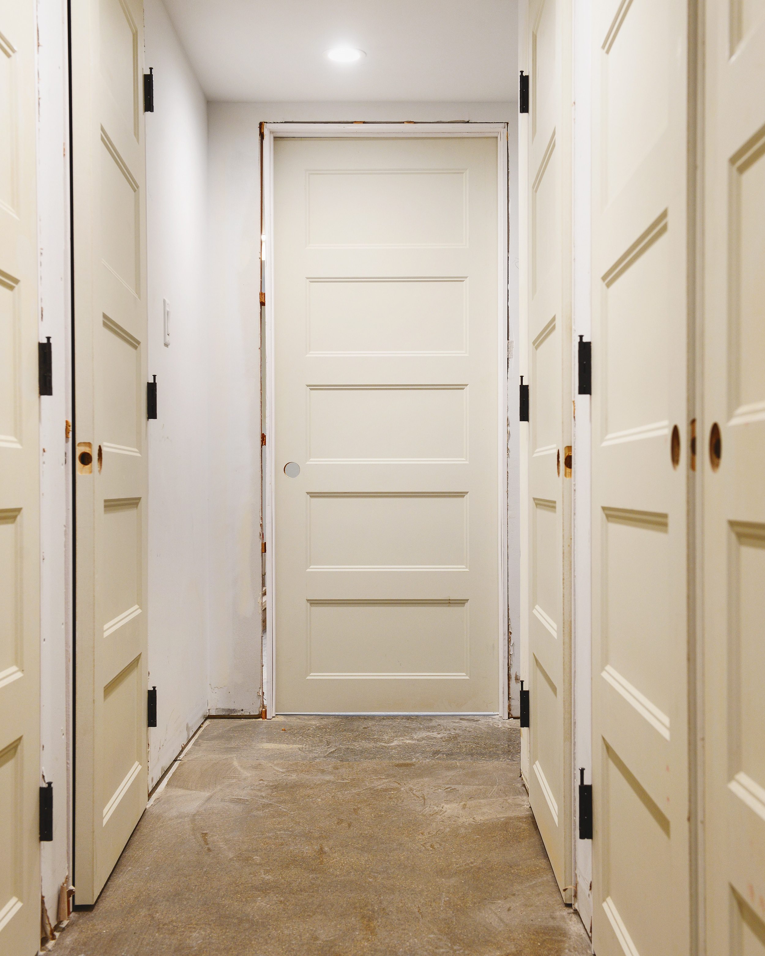 A long hallway full of newly installed primed doors // via yellow brick home