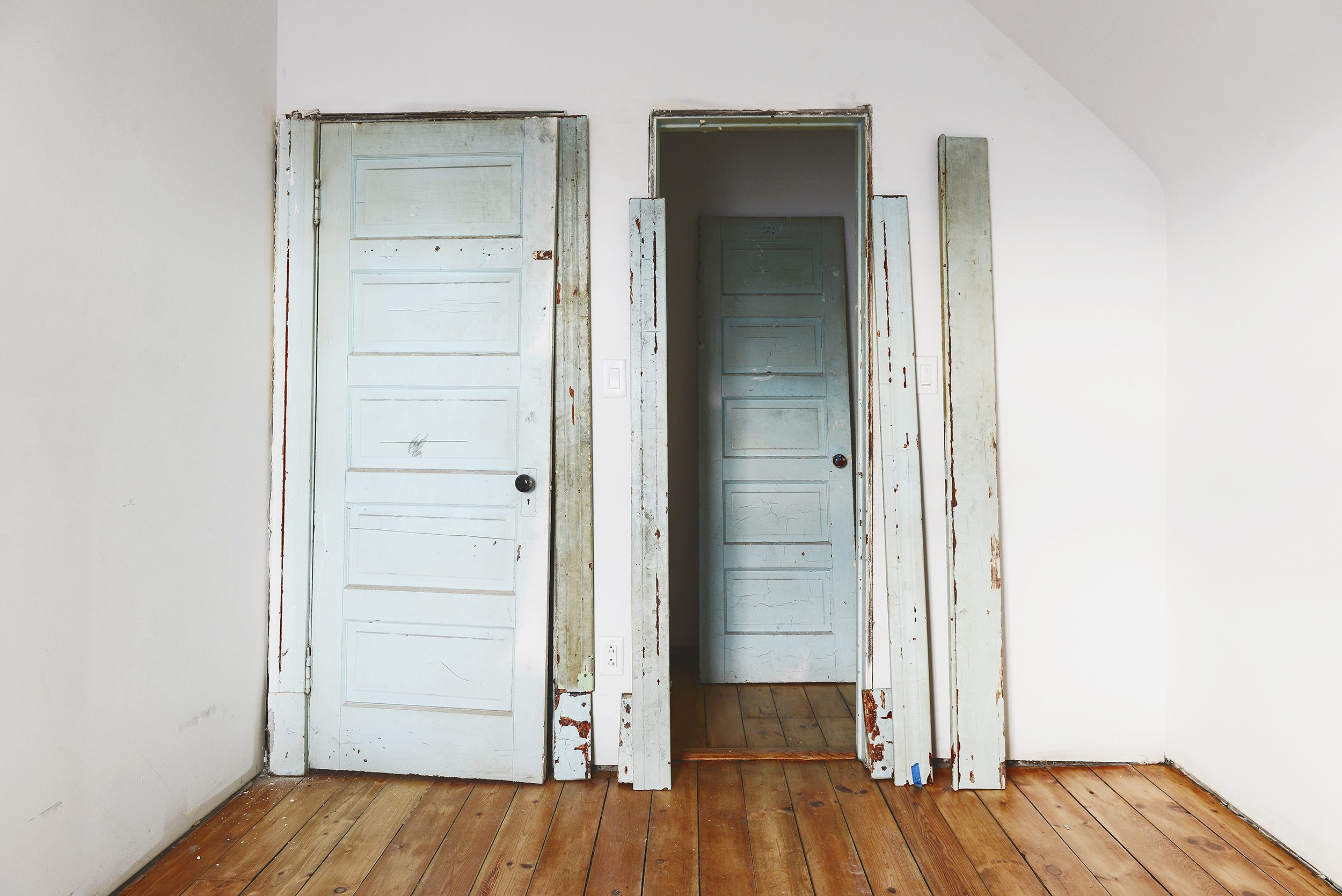 Two blue vintage doors are flanked by the trim that will eventually case them in // via Yellow Brick Home 