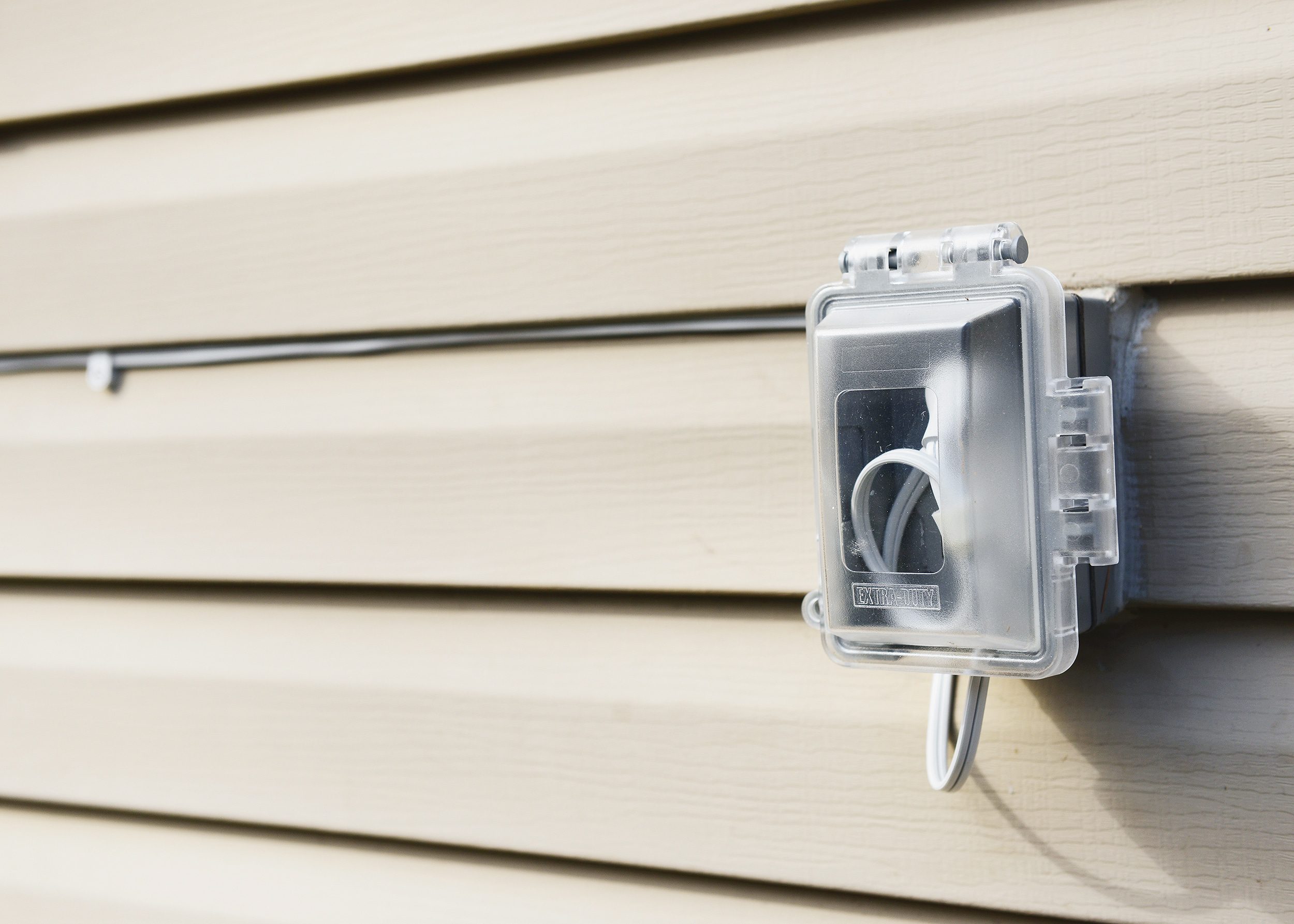 A weatherproof exterior outlet conceals the cable of an outdoor security camera // via yellow brick home