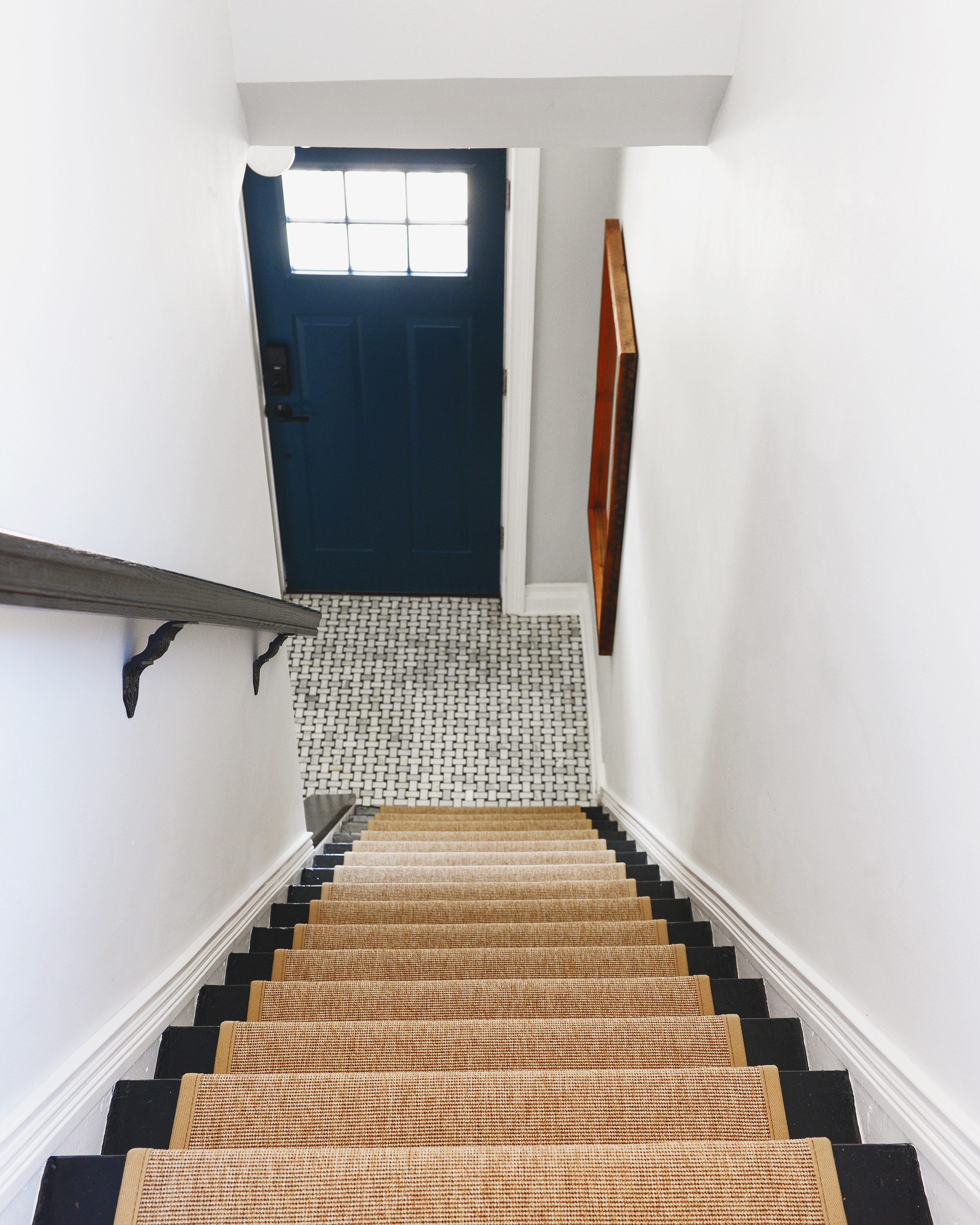 A white entryway with basketweave marble tile and neutral stair runner | Entryway makeover decisions | via Yellow Brick Home