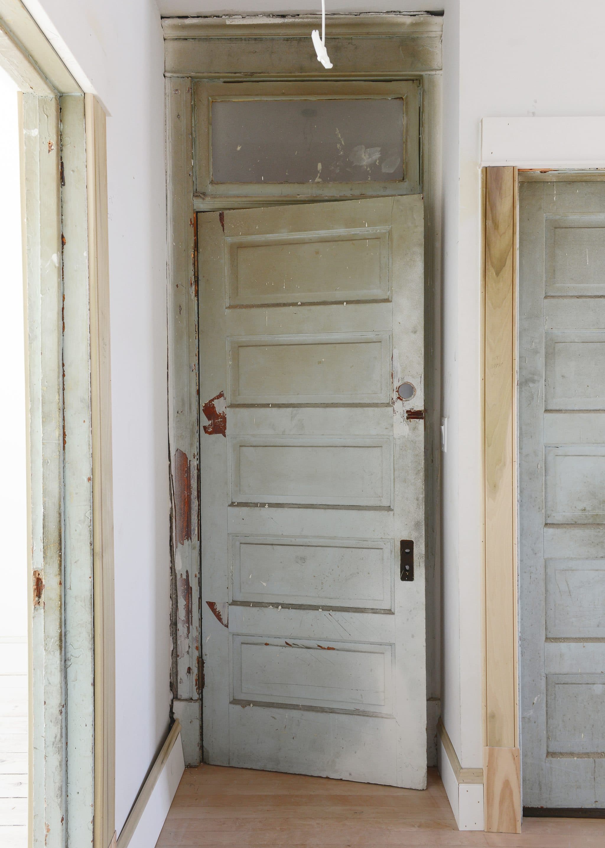 A vintage door is flanked by two other doors that are newly trimmed // via Yellow Brick Home