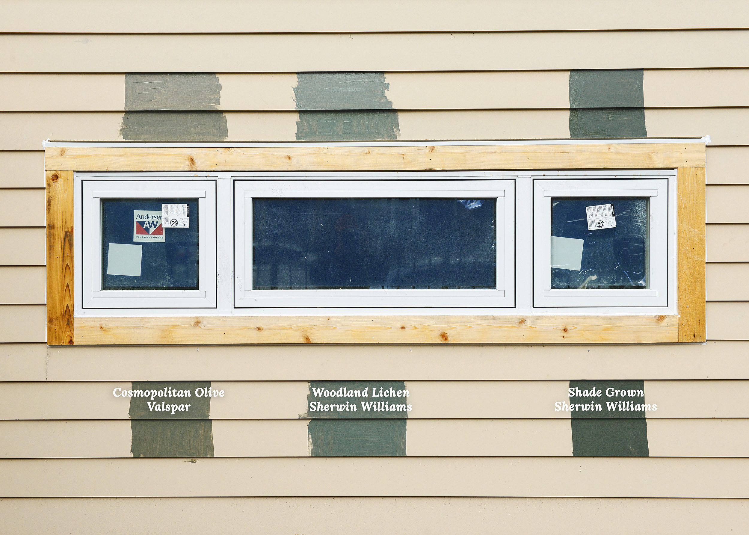 Three different olive green paint samples have been applied to new siding on a house under construction // via Yellow Brick Home