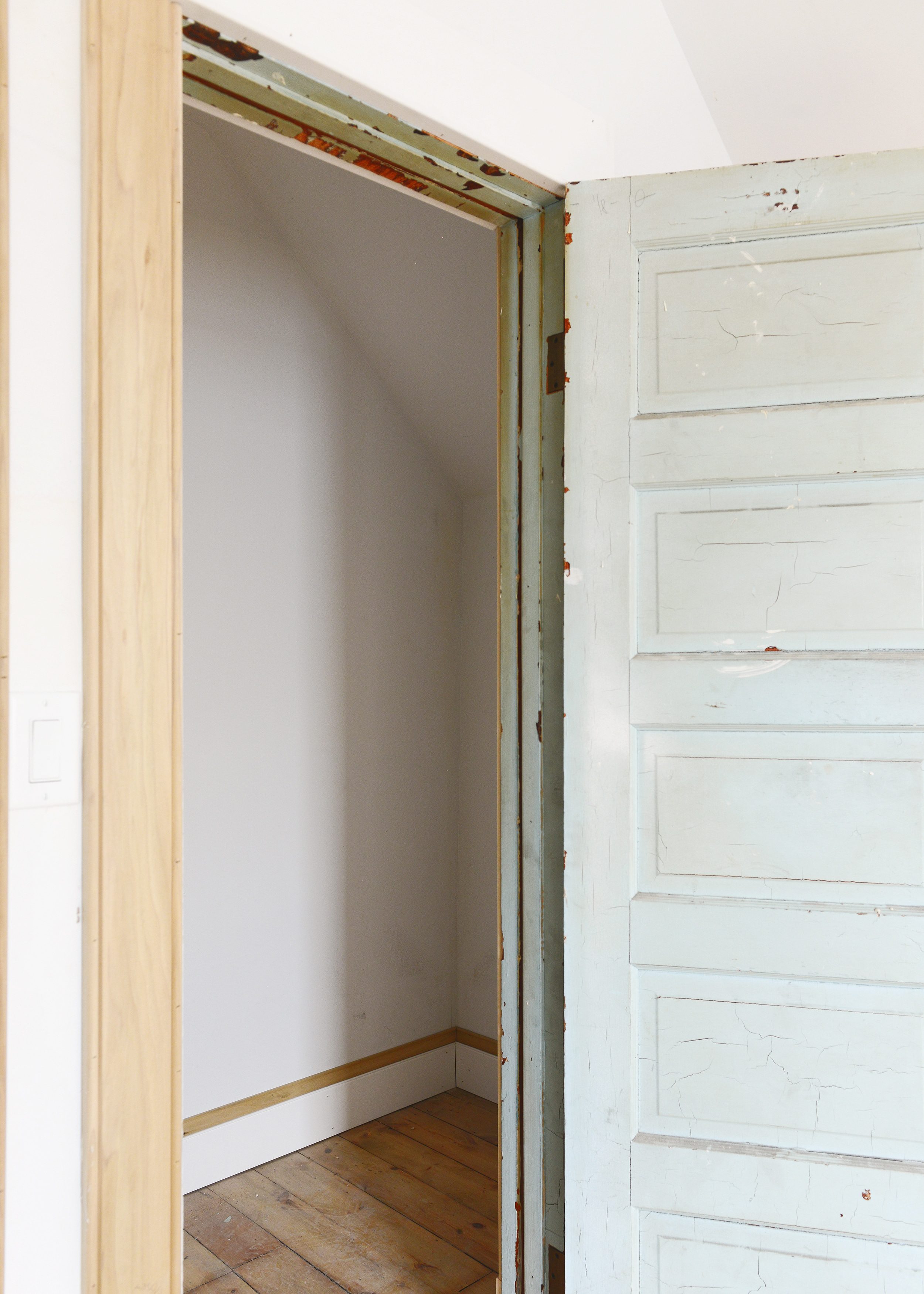 Looking into a vintage closet with new millwork and a light blue 5 panel door | via Yellow Brick Home