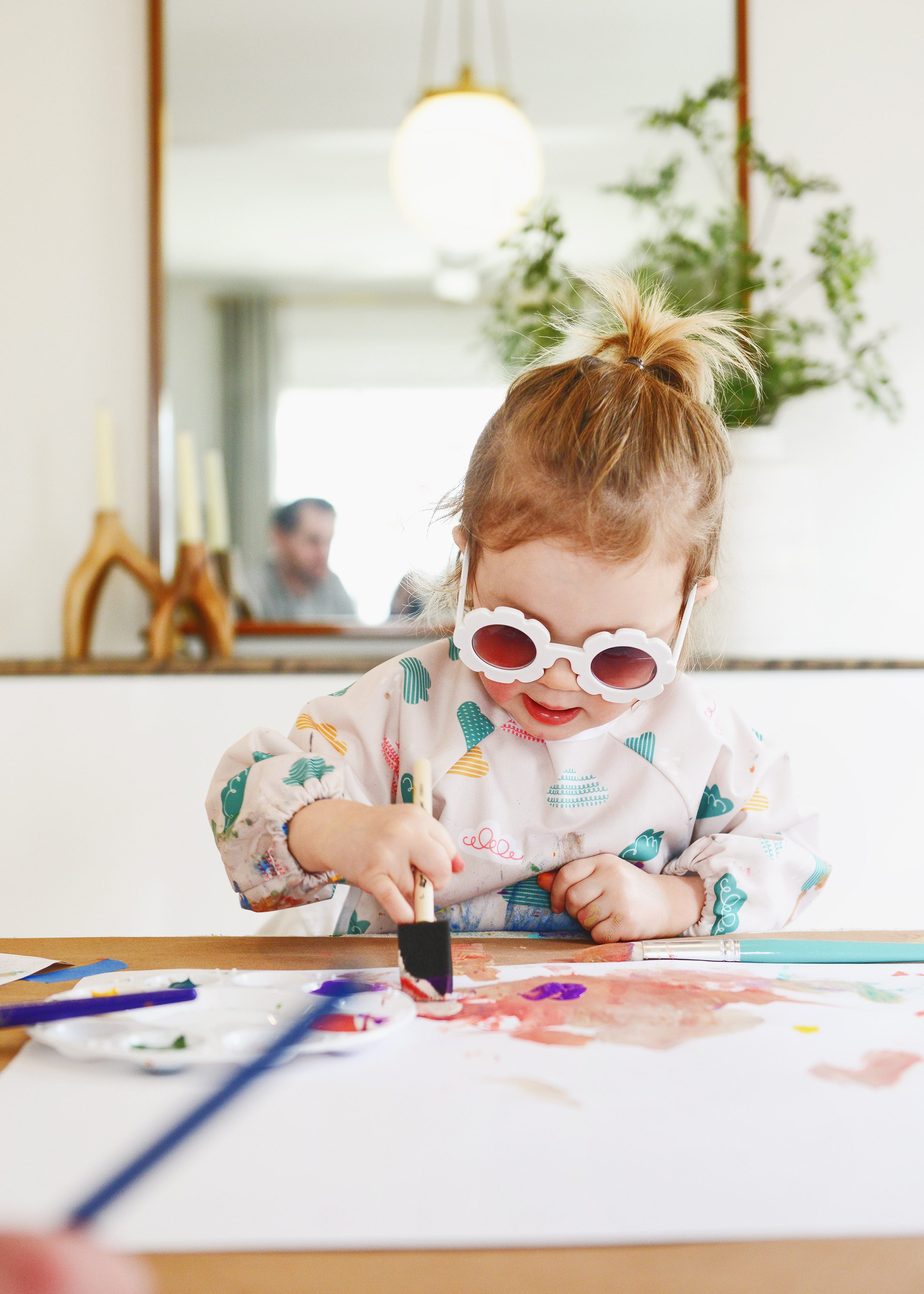 Lucy using a foam brush to make her painting | How to have a successful family art party! via Yellow Brick Home