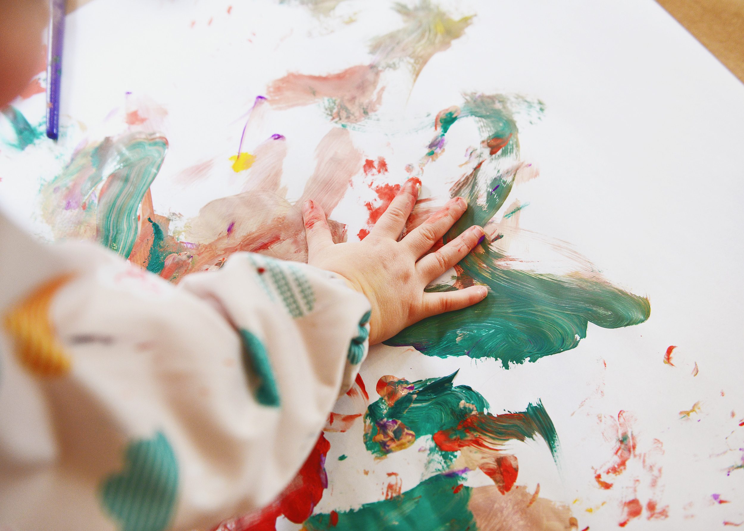 Lucy using her hands to create her painting | How to have a successful family art party! via Yellow Brick Home