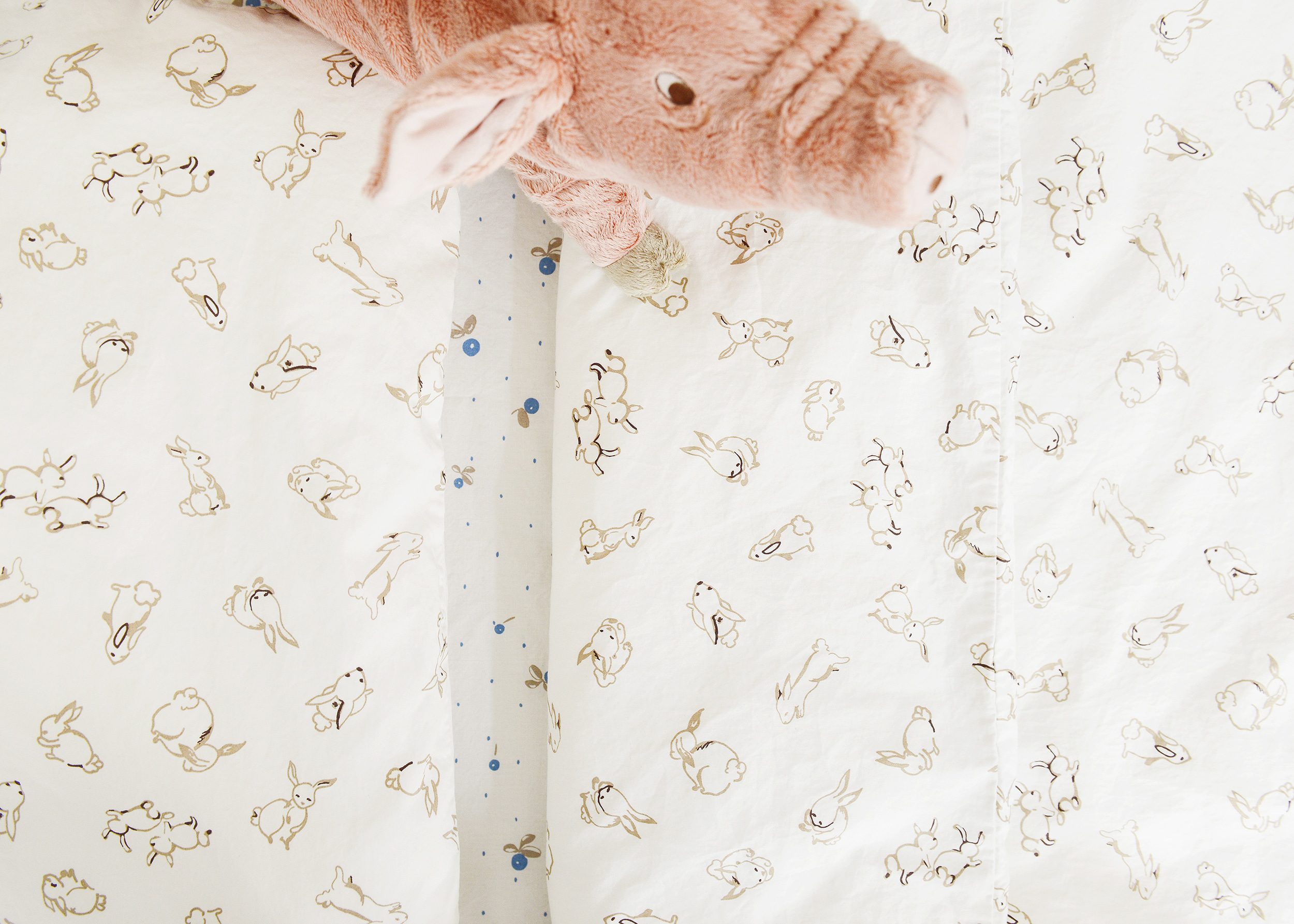 Detail shot of bedding on a crib with a toddler rail, IKEA bedding | via Yellow Brick Home