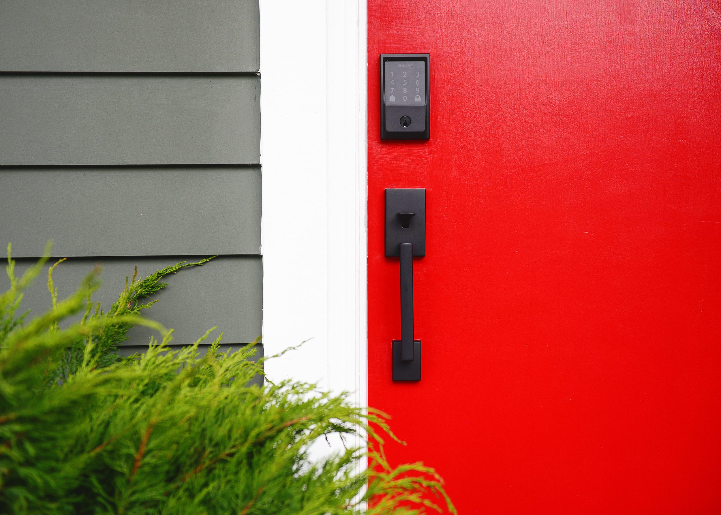 Detail of Schlage Encode smart lock on a bright red front door | via Yellow Brick Home