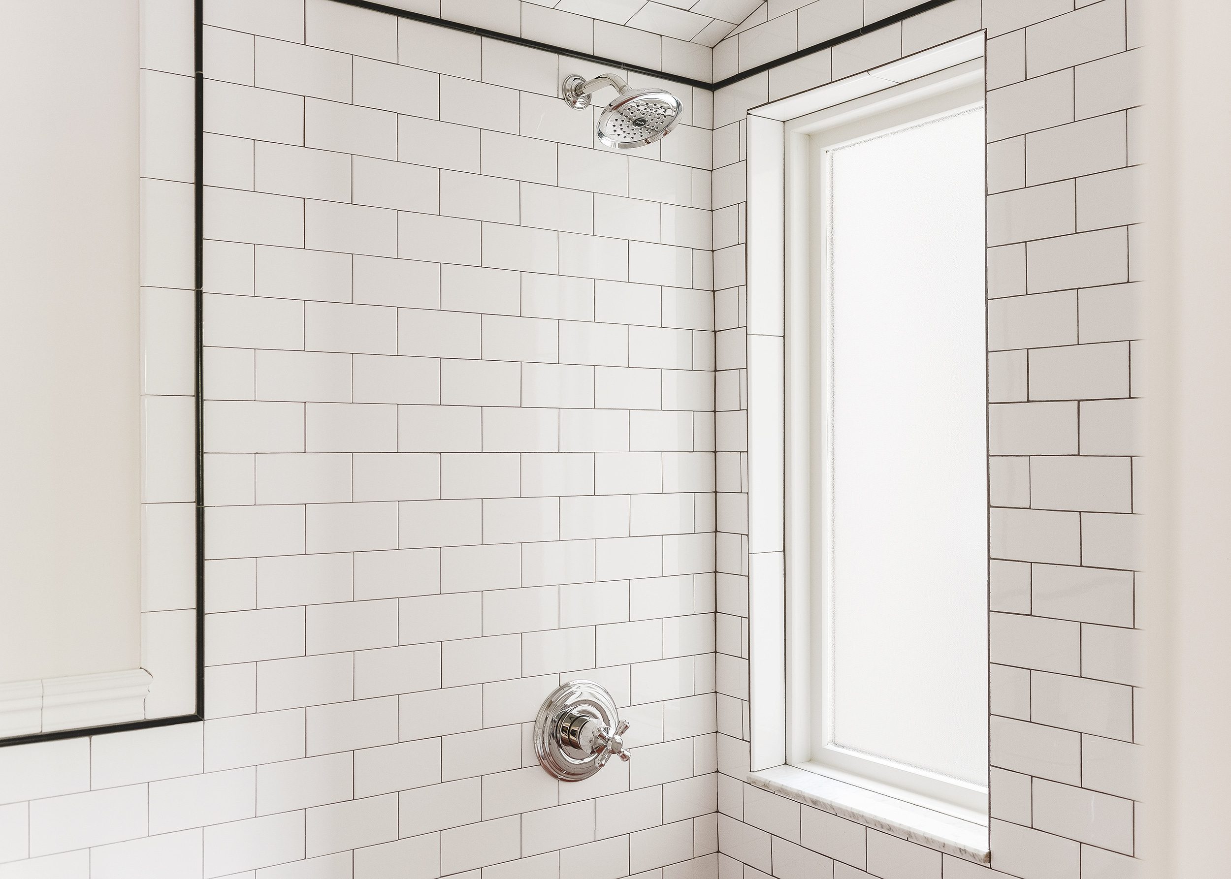 A newly installed obscure glass Andersen window in a bathroom with white subway tile walls, dark grout and a vintage pink tub // via Yellow Brick Home
