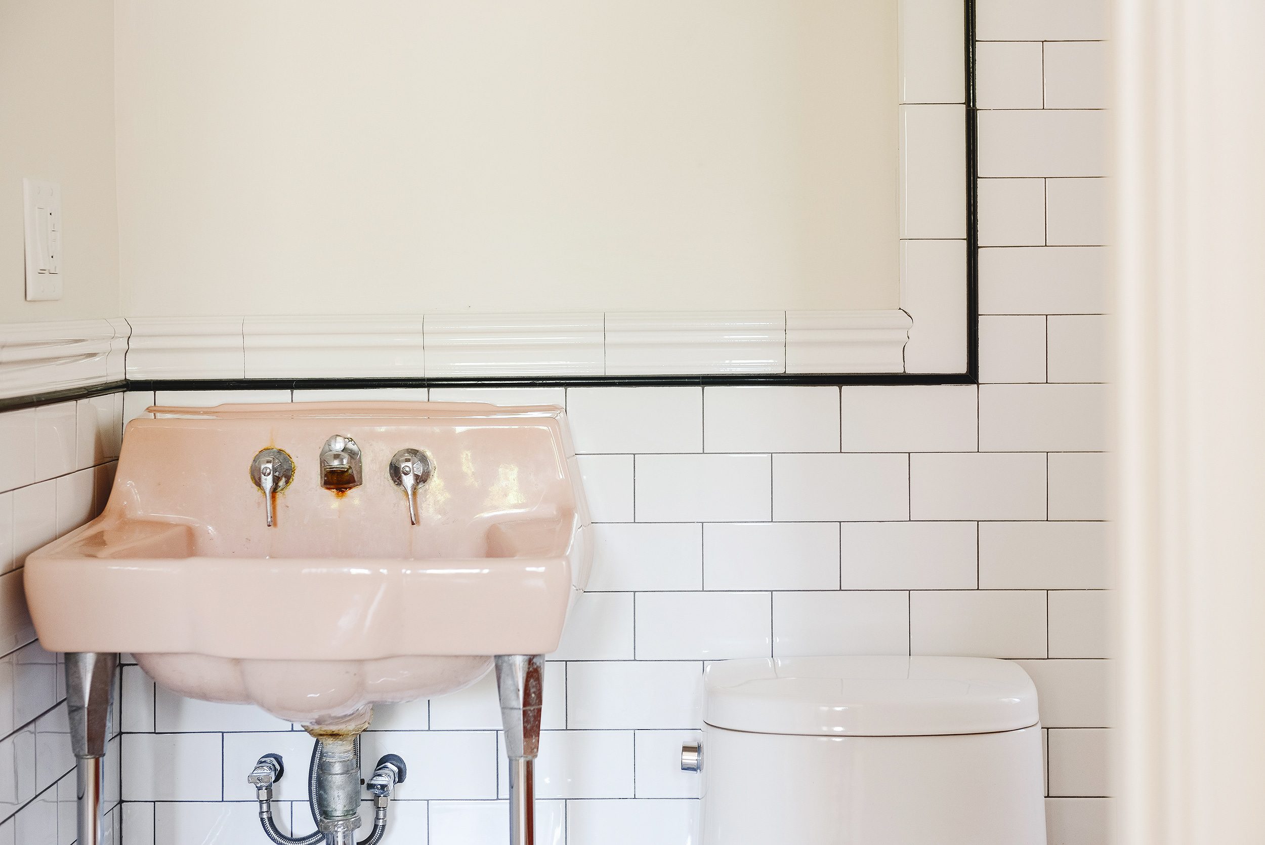 detail of the pink sink with glossy white subway tile | via Yellow Brick Home