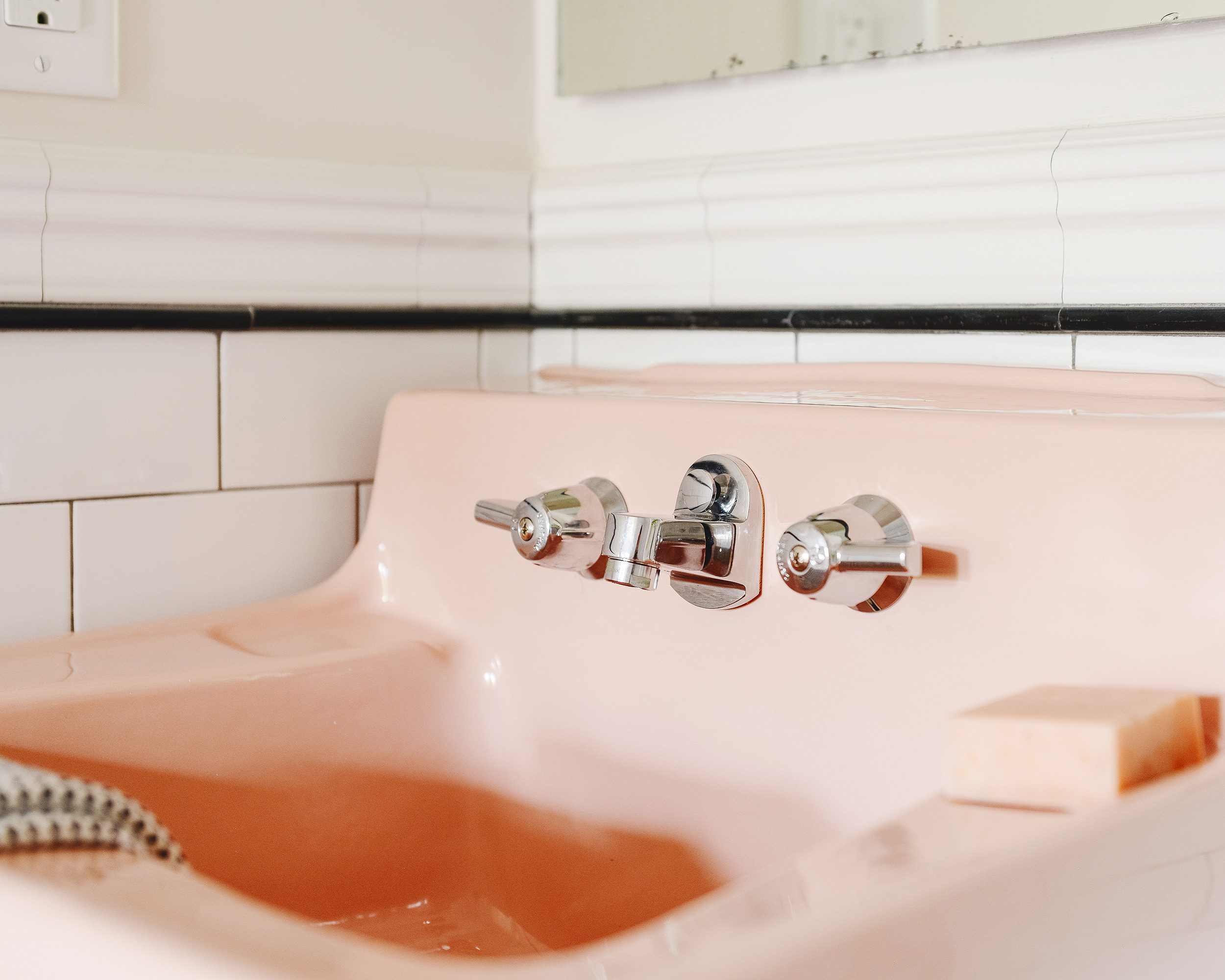 A vintage pink sink, detail with chrome widespread faucet | via Yellow Brick Home