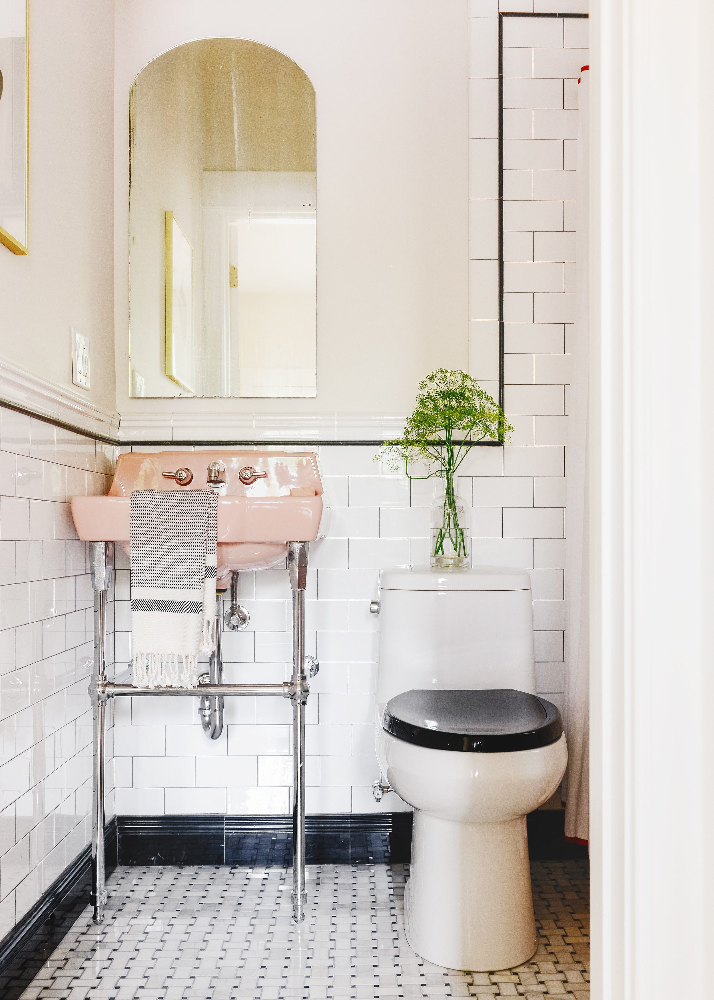 A small white bathroom with classic subway tile and a vintage pink bathtub | via Yellow Brick Home