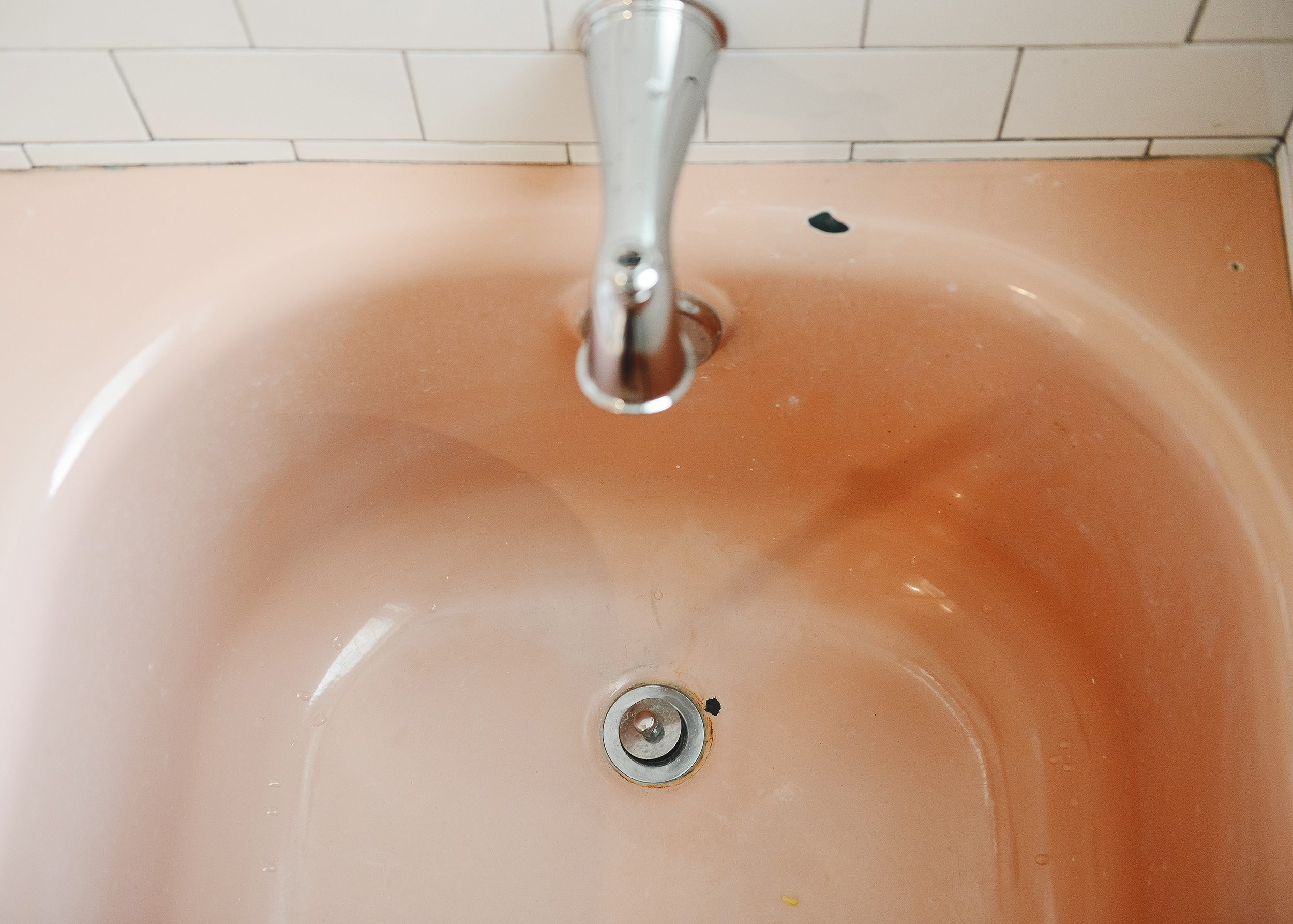 Our vintage pink bathtub before being reglazed was full of chips and rust | via Yellow Brick Home