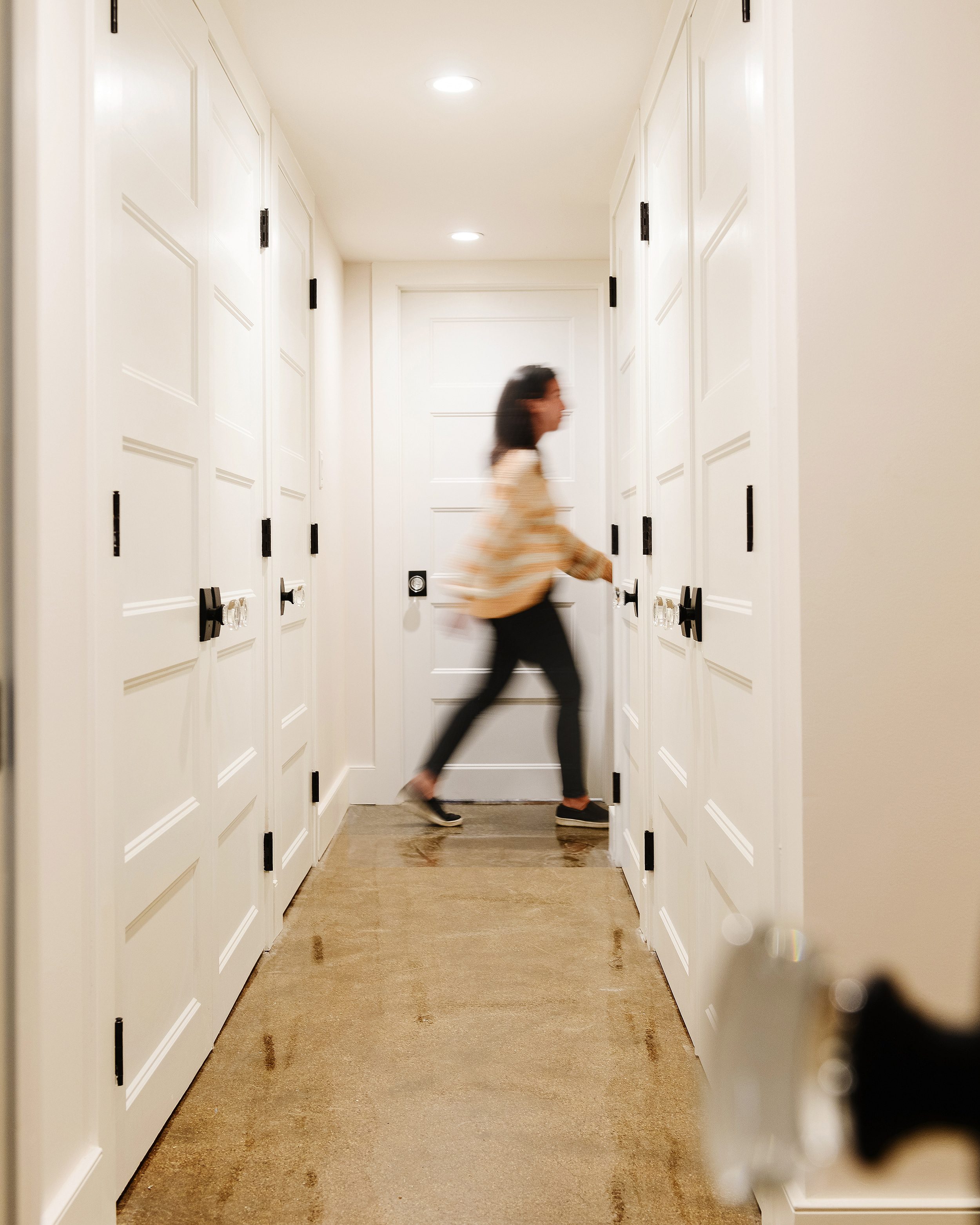Schlage custom hobson glass knob detail, Kim walking down a hallway with all new door hardware | via Yellow Brick Home