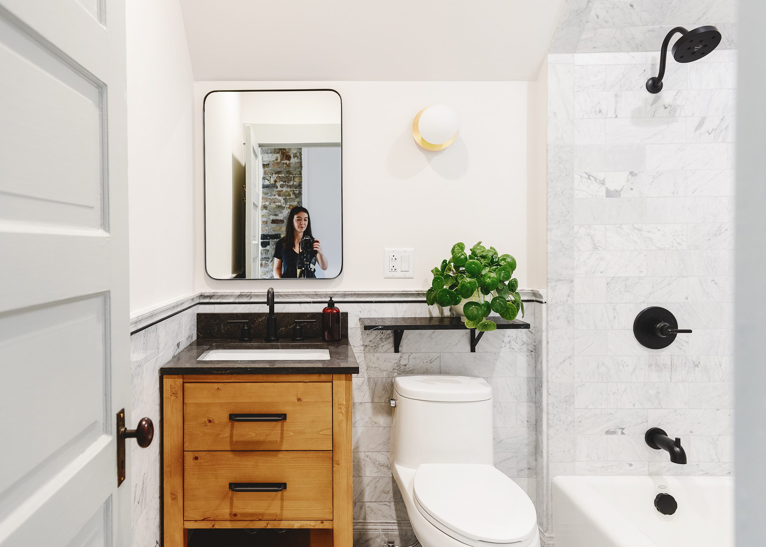 Bathroom with marble and SW Magnetic Gray trim, wood vanity and brass accents | via Yellow Brick Home